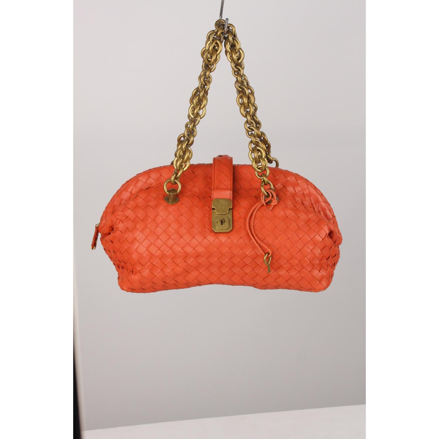 BOTTEGA VENETA Intrecciato woven Bowler bag in orange color. Upper zipper closure and fold-over strap with front key closure (key is included). Tan suede lining with 1 side zip pocket inside. Chain handles. 'BOTTEGA VENETA - Made in italy' engraved