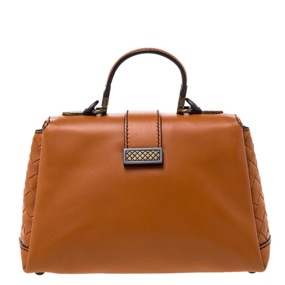 This Bottega Veneta mini Piazza bag arrives in a structured shape and grand design. Crafted from orange leather, it has a press-lock on the flap, a top handle and a shoulder strap that is detachable. The flap secures a suede interior and overall,