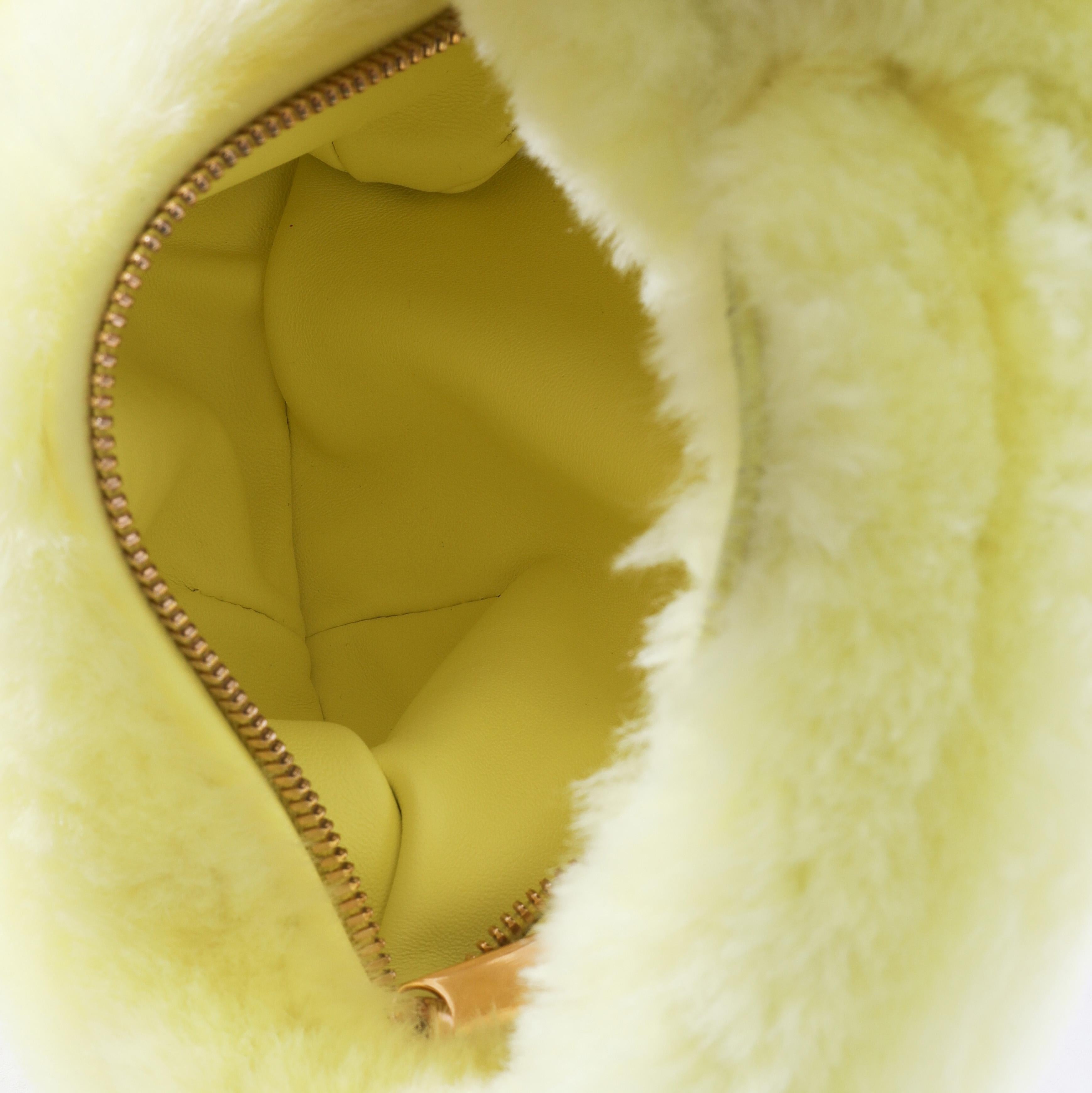 Listing Title: Bottega Veneta Pale Yellow Shearling Mini Jodie
SKU: 131256
MSRP: 3200.00
Condition: Pre-owned 
Condition Description: Made from leather in the signature Intrecciato weave, the mini Jodie bag from Bottega Veneta is exemplary of the