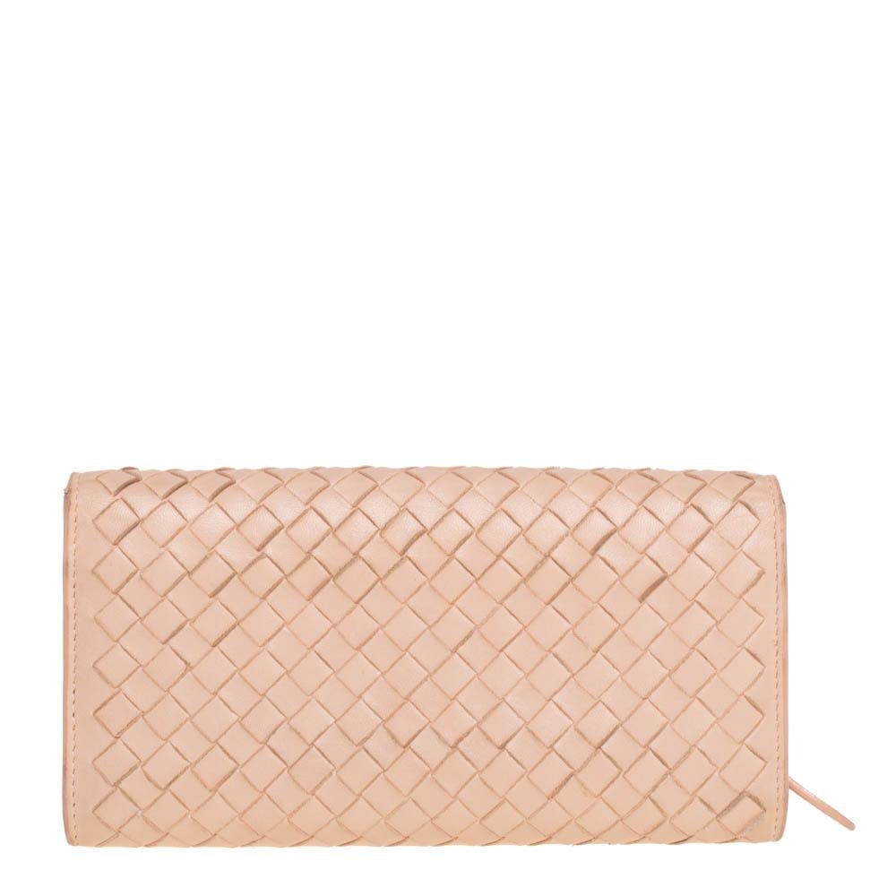 This continental wallet by Bottega Veneta is designed in the signature Intrecciato pattern. Crafted from leather, this peach wallet is equipped with a flap closure that opens to a leather and fabric-lined interior housing multiple card slots, a