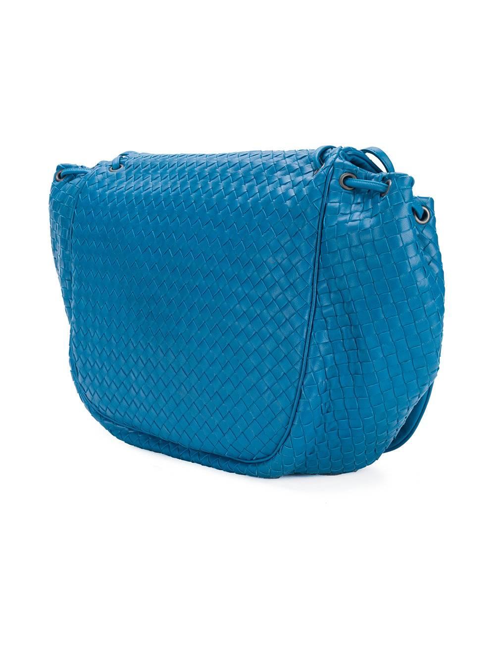 This peacock blue Nappa leather braided flap shoulder bag from Bottega Veneta features an adjustable shoulder strap, a foldover top with magnetic closure, a main internal compartment, an internal zipped pocket, an embossed internal logo stamp, a