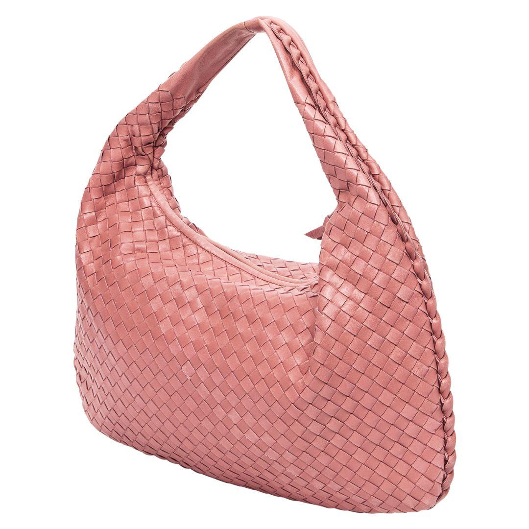 Bottega Veneta's Medium Veneta Hobo is a vision in pink Intecciato leather with silver hardware, a suede interior with a zippered pocket, all secured by a smooth zipper closure.

SPECIFICS
• Length: 15.7