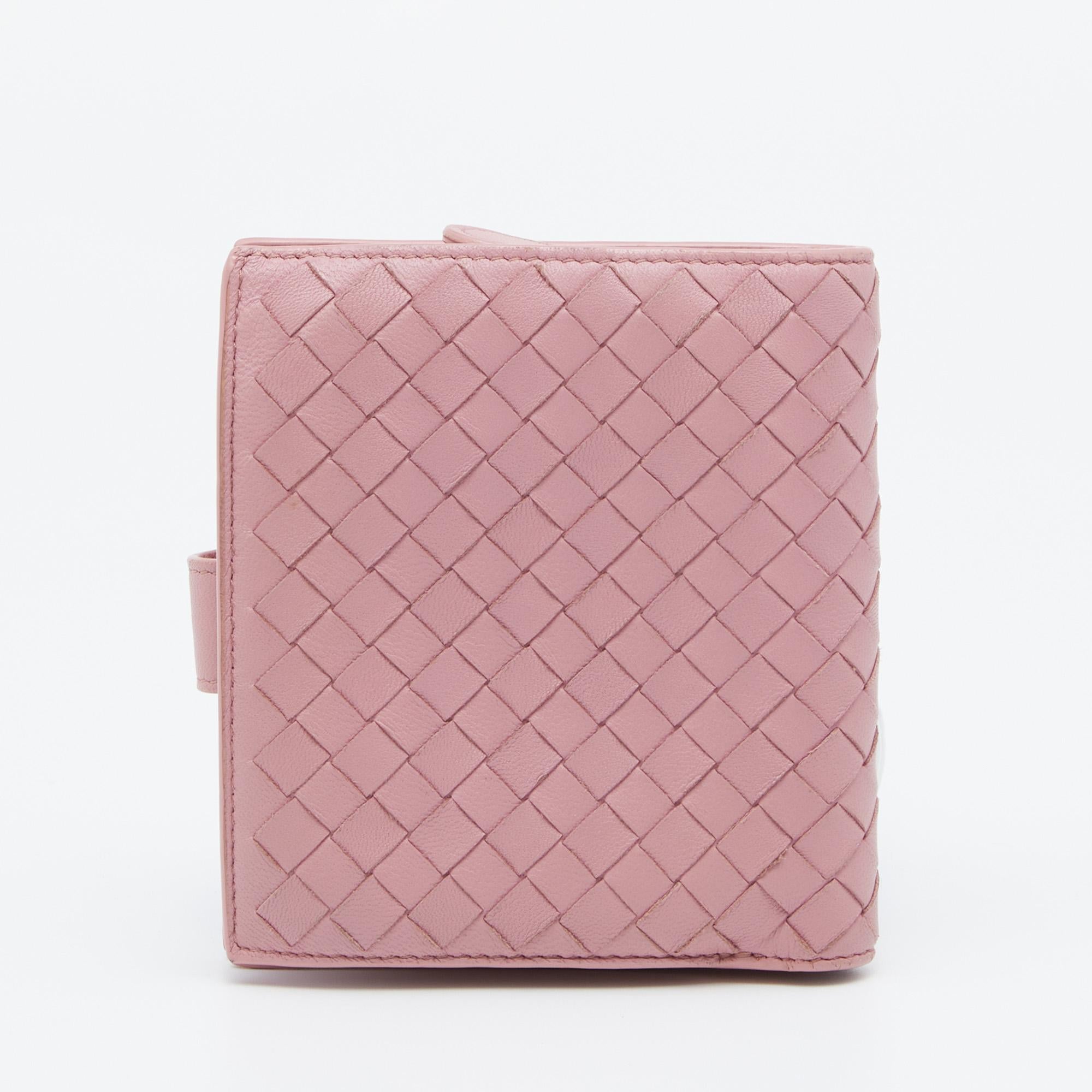 This compact wallet from Bottega Veneta is chic and practical! Flawlessly crafted in beautiful pink Nappa leather, it features the signature hand-woven Intrecciato pattern and snaps closure. The leather interior features one zipped compartment, two