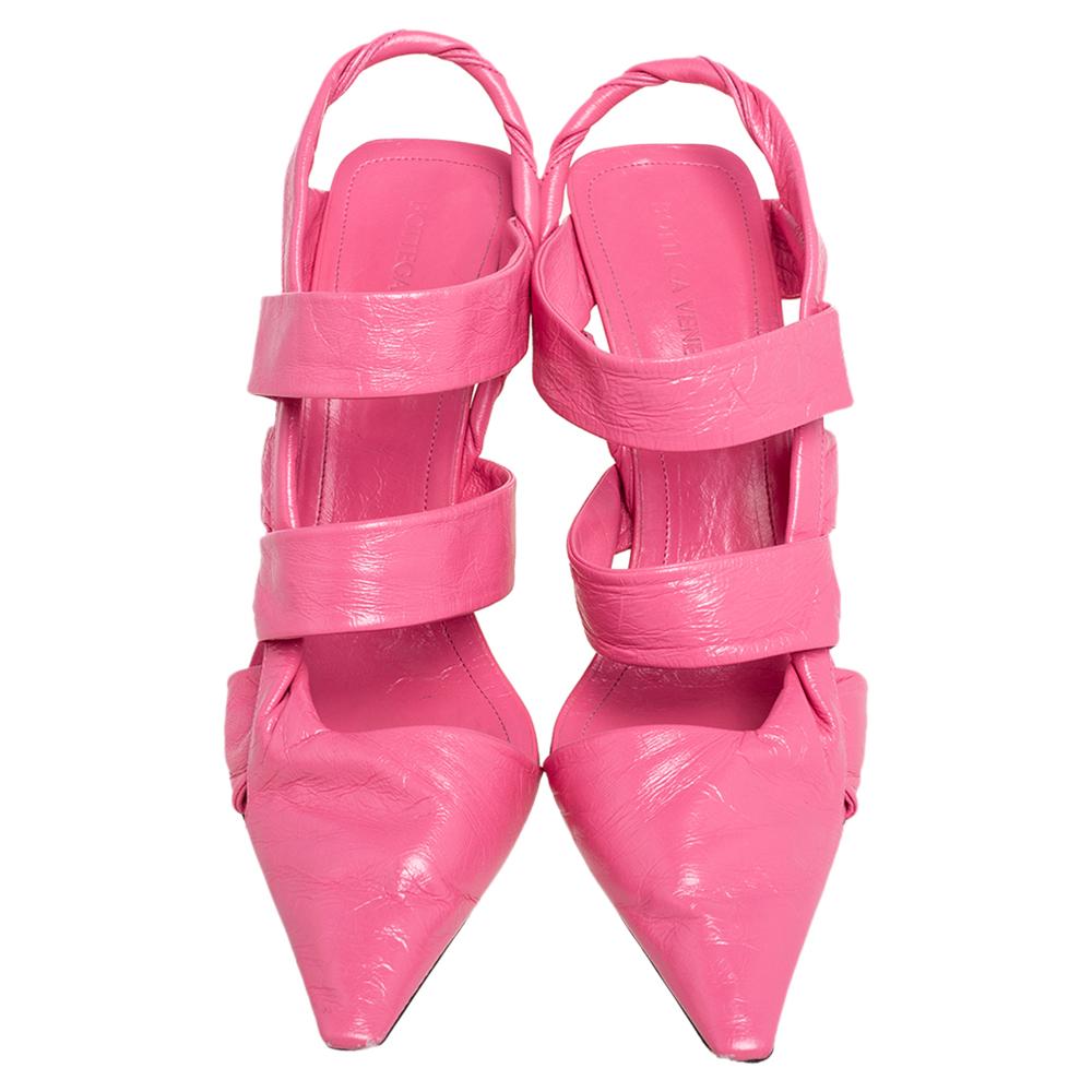 Let out cool, colorful vibes with these sandals by Bottega Veneta. Made using pink leather, these uniquely carved sandals inspire you to step out of the conventional footwear choices. They feature 9 cm pointy heels and come with a slingback for