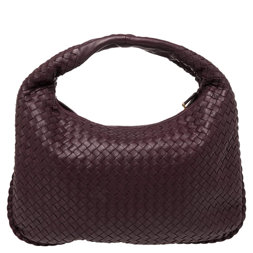 The excellent craftsmanship of this Bottega Veneta hobo ensures a brilliant finish and a rich appeal. Woven from leather in their signature Intrecciato pattern, the plum-hued bag is provided with minimal hardware. It features a loop handle and a top