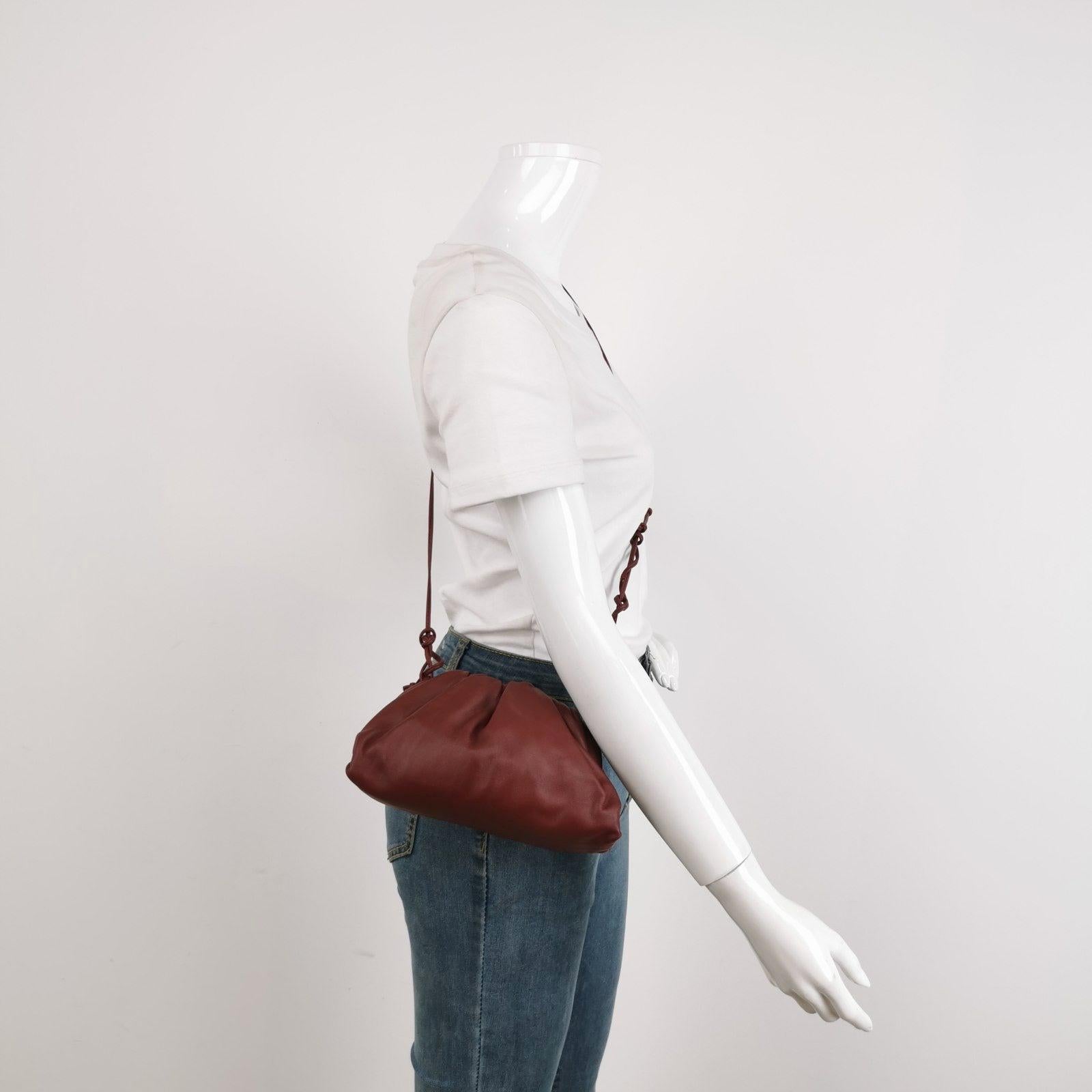 Bottega Veneta Pouch Mini Burgundy Leather These are professional photos of the actual bag offered by Luxbags. Discover the sophisticated luxury of the Bottega Veneta Pouch Mini. Revel in its stylish cult design, handcrafted in a luxurious burgundy