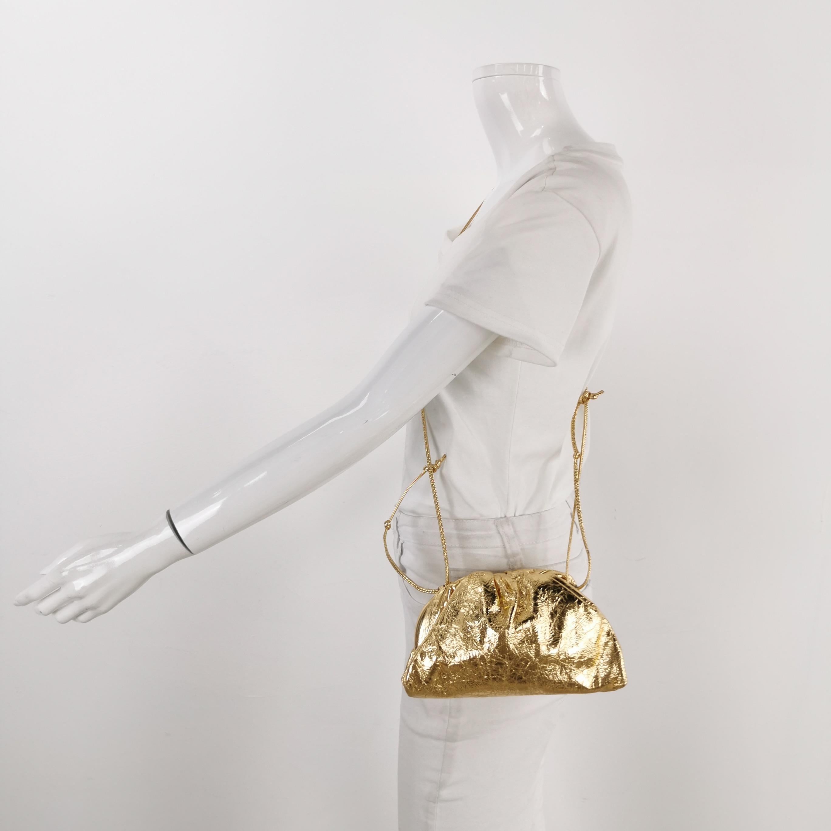 Bottega Veneta Pouch Mini Gold Lambskin Leather Crossbody Bag These are professional photos of the actual bag offered by Luxbags. Discover the sophisticated luxury of the Bottega Veneta Pouch Mini. Revel in its stylish cult design, handcrafted in a
