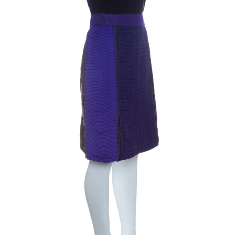 The house of Bottega Veneta brings luxurious fashion to your wardrobes with this chic pencil skirt in a eye-catching shade of purple, contrasted with brown. Characterized by a pleated detailing on the surface, this skirt features a plastic panel,