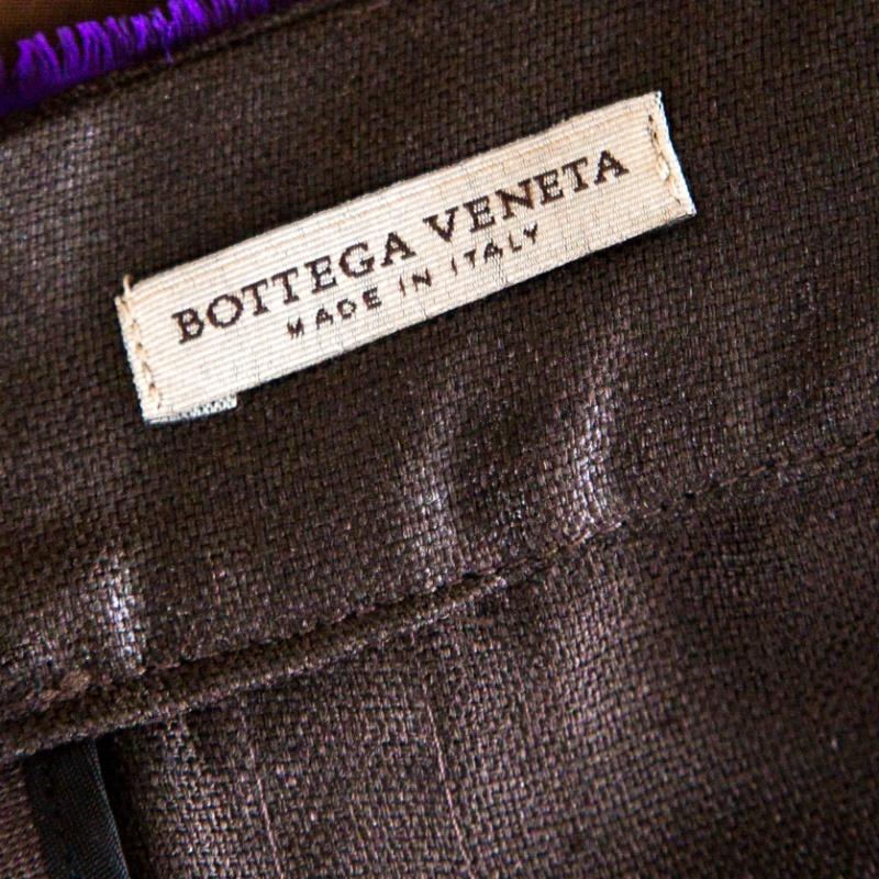 The house of Bottega Veneta brings luxurious fashion to your wardrobes with this chic pencil skirt in a eye-catching shade of purple, contrasted with brown. Characterized by a pleated detailing on the surface, this skirt features a plastic panel,