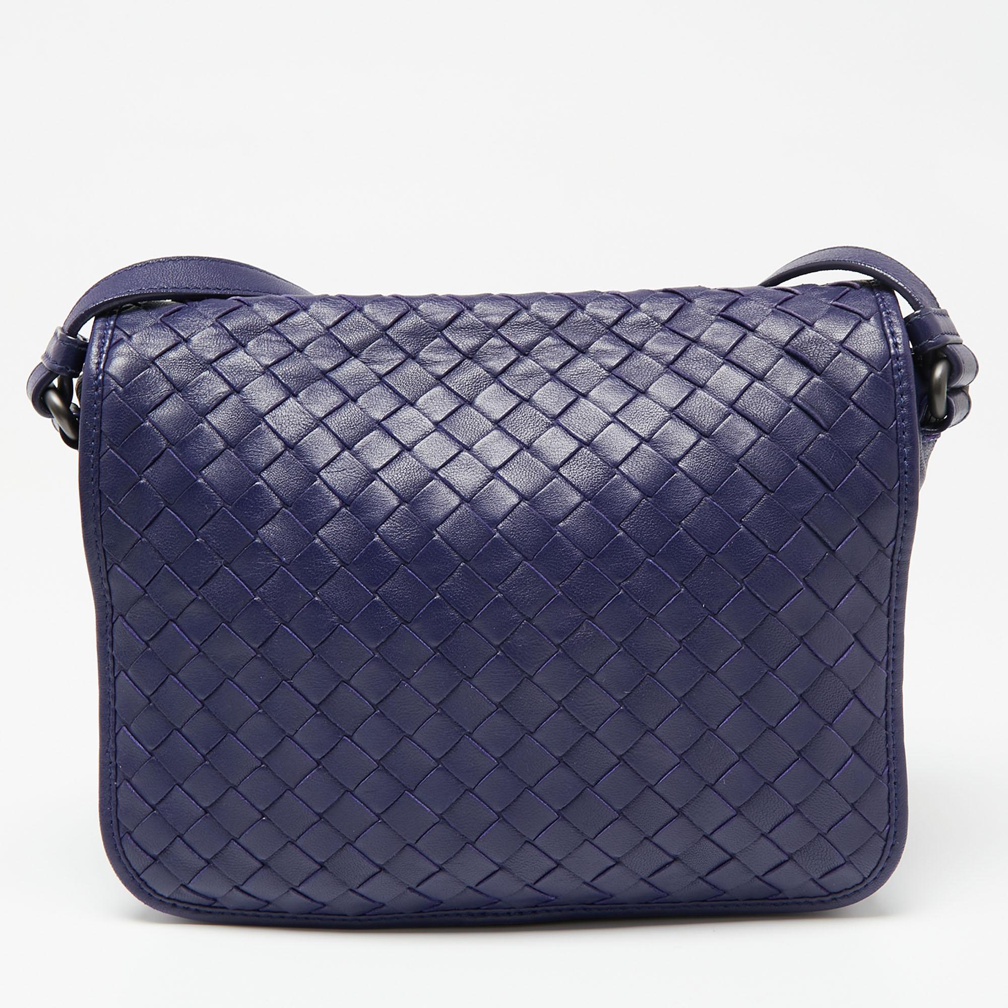 Swap that everyday tote with this charming crossbody bag from the house of Bottega Veneta. The purple leather bag exhibits the brand's iconic Intrecciato signature. It comes fitted with an adjustable shoulder strap and a flap style. The spacious