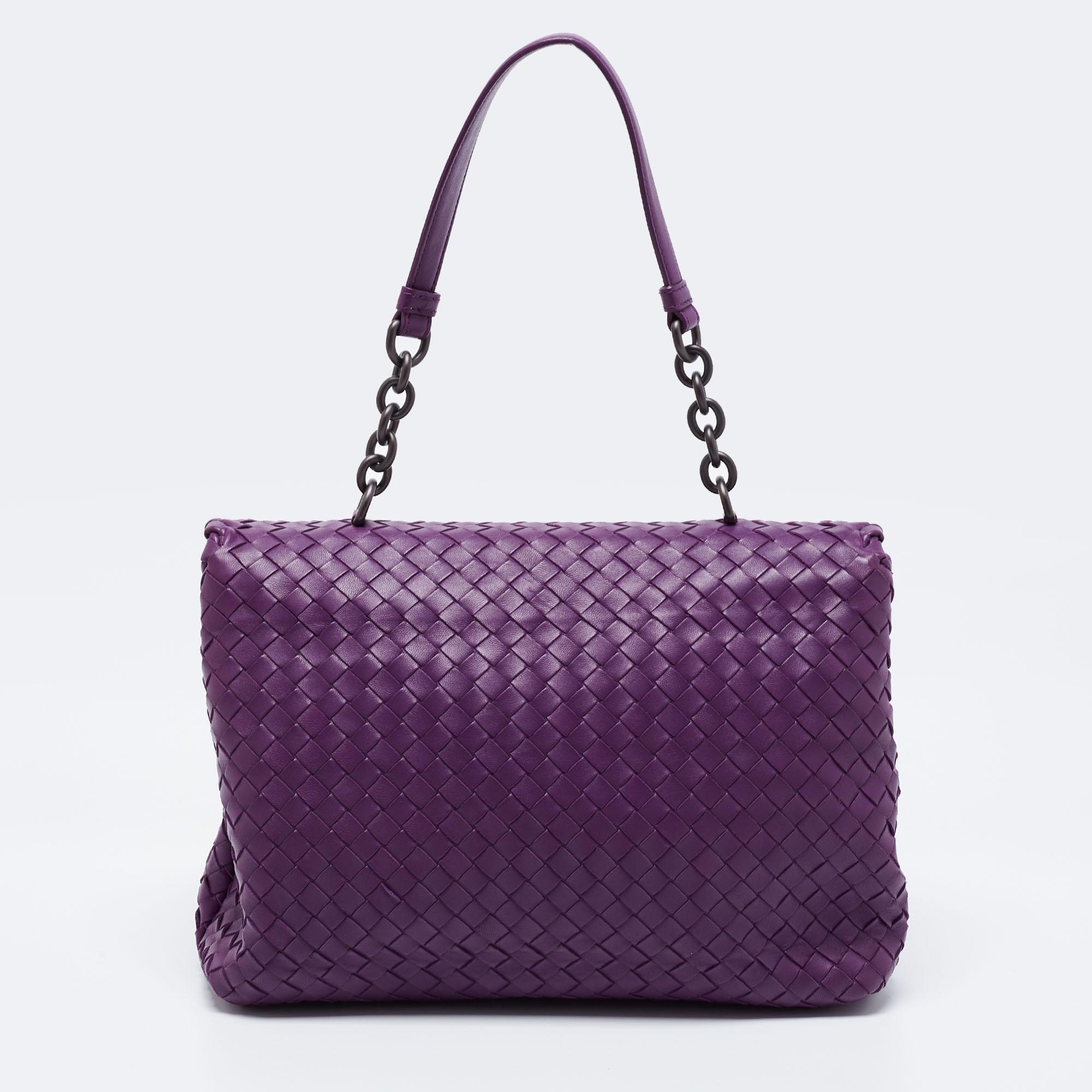 Named after the renaissance building 'Teatro Olimpico,' the Bottega Veneta Olimpia bag reflects the brand's faultless weaving technique. This purple creation comes made from Intrecciato leather and is held by a chain-leather handle at the top. Lined