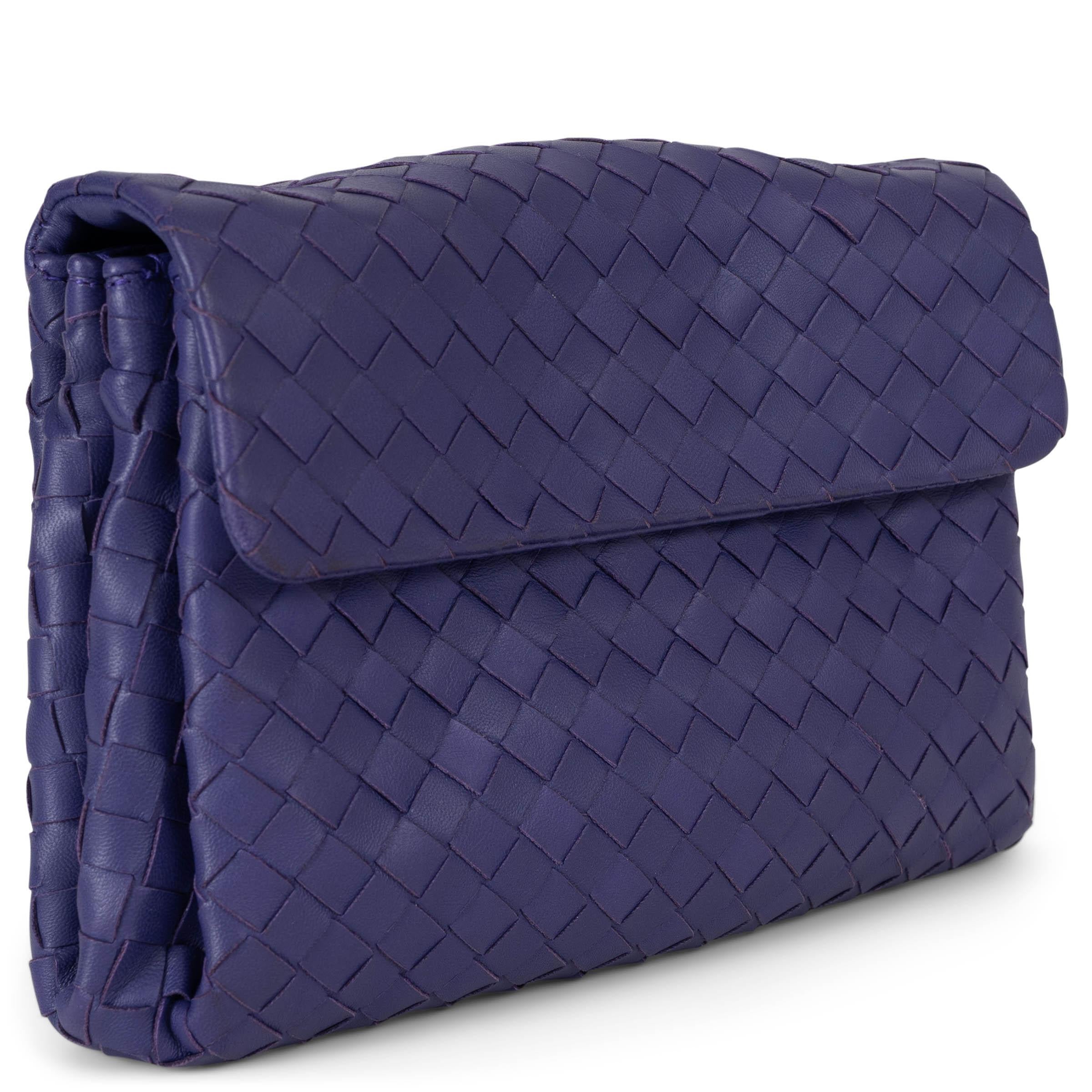 Questa pochette Bottega Veneta, autentica al 100%, è realizzata in pelle intrecciata Anemone (viola elettrico). Si chiude con una patta magnetica ed è foderata in tessuto marrone. L'interno è diviso in due scomparti, separati da una tasca centrale