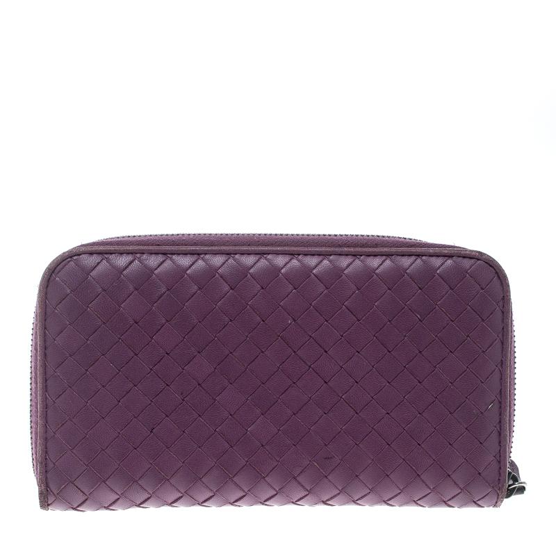 Luxe and classy, this zip around wallet is from Bottega Veneta. It has been crafted from purple leather, detailed with their signature Intrecciato pattern all over and equipped with a zipper leading to multiple slots and a zip pocket for you to