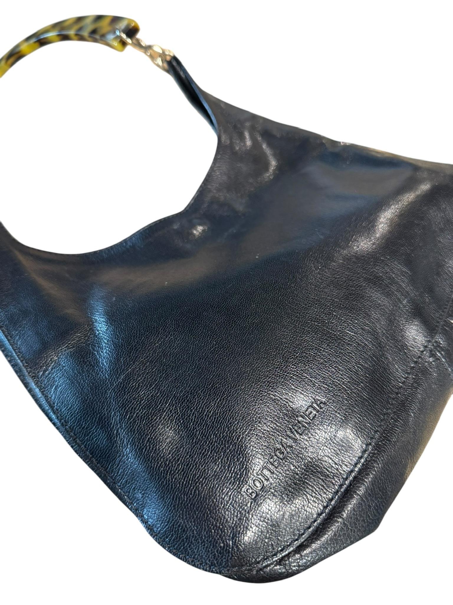 Vintage Bottega Veneta Borsa a tracolla in pelle nera rara con manico in lucite tartarugata. Questa borsa a tracolla vintage di Bottega Veneta è un raro reperto che unisce l'eleganza minimalista a dettagli scultorei e audaci. Realizzata in morbida