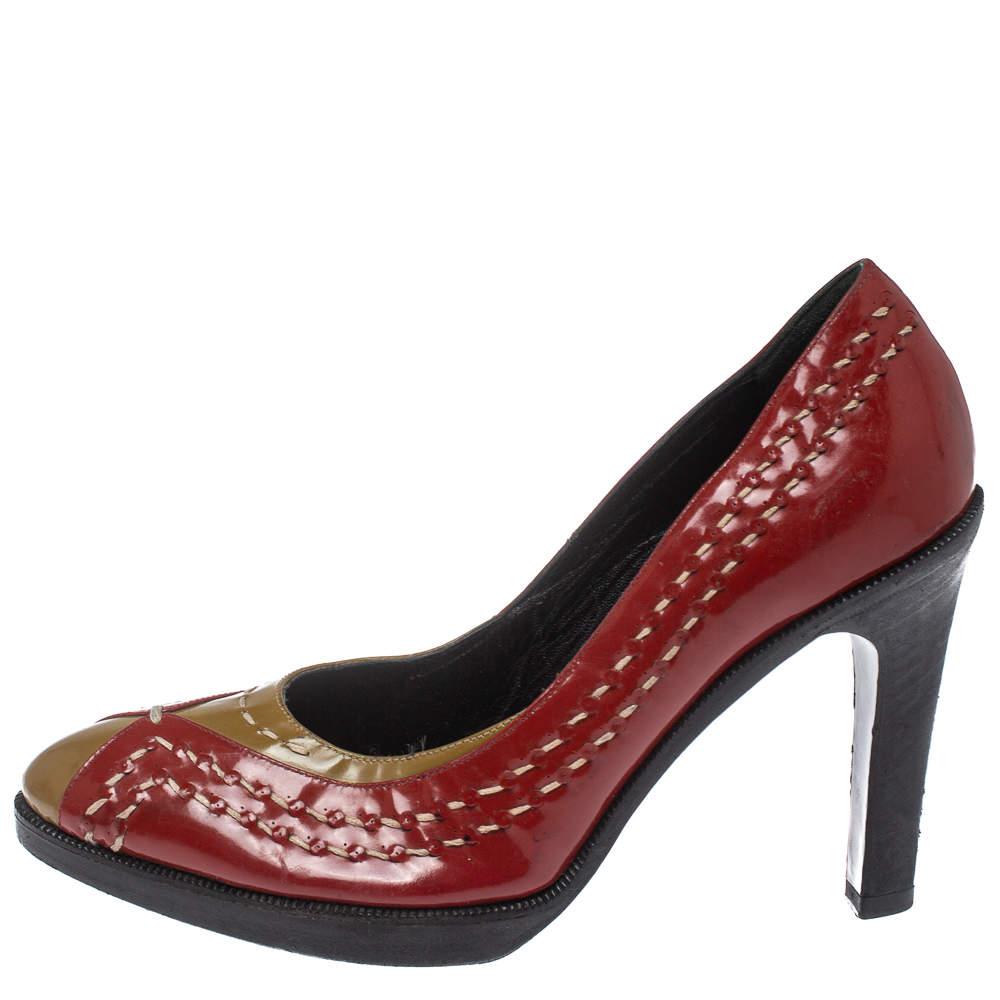 Bottega Veneta's pumps are crafted in Italy from brown patent leather than overlaid with red-colored patent leather panels featuring neat stitching details. They are set on 10 cm heels and have almond toes. Wear them with dresses, evening gowns, and