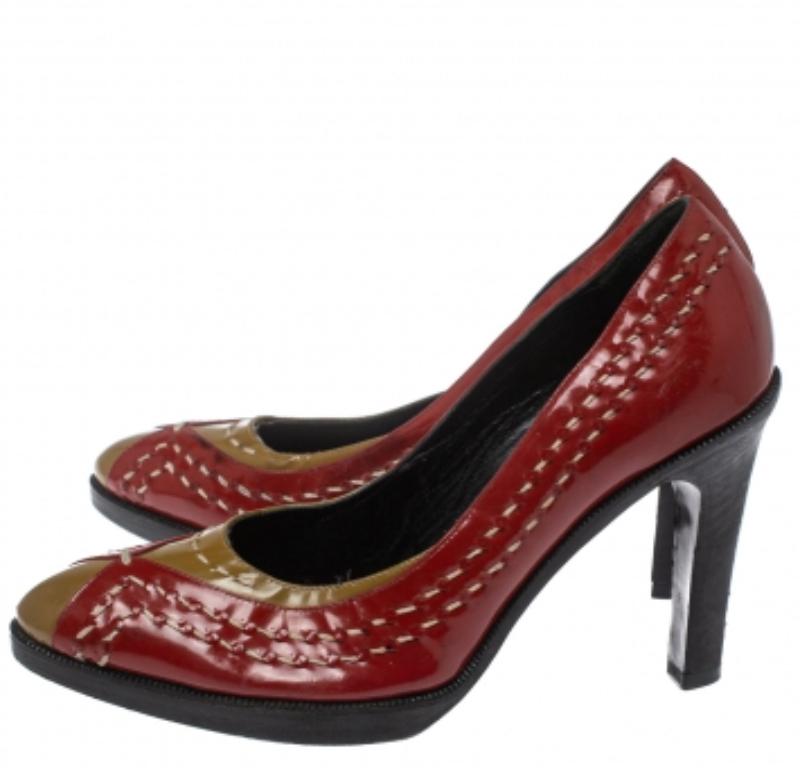 Bottega Veneta's pumps are crafted in Italy from brown patent leather than overlaid with red-colored patent leather panels featuring neat stitching details. They are set on 10 cm heels and have almond toes. Wear them with dresses, evening gowns, and
