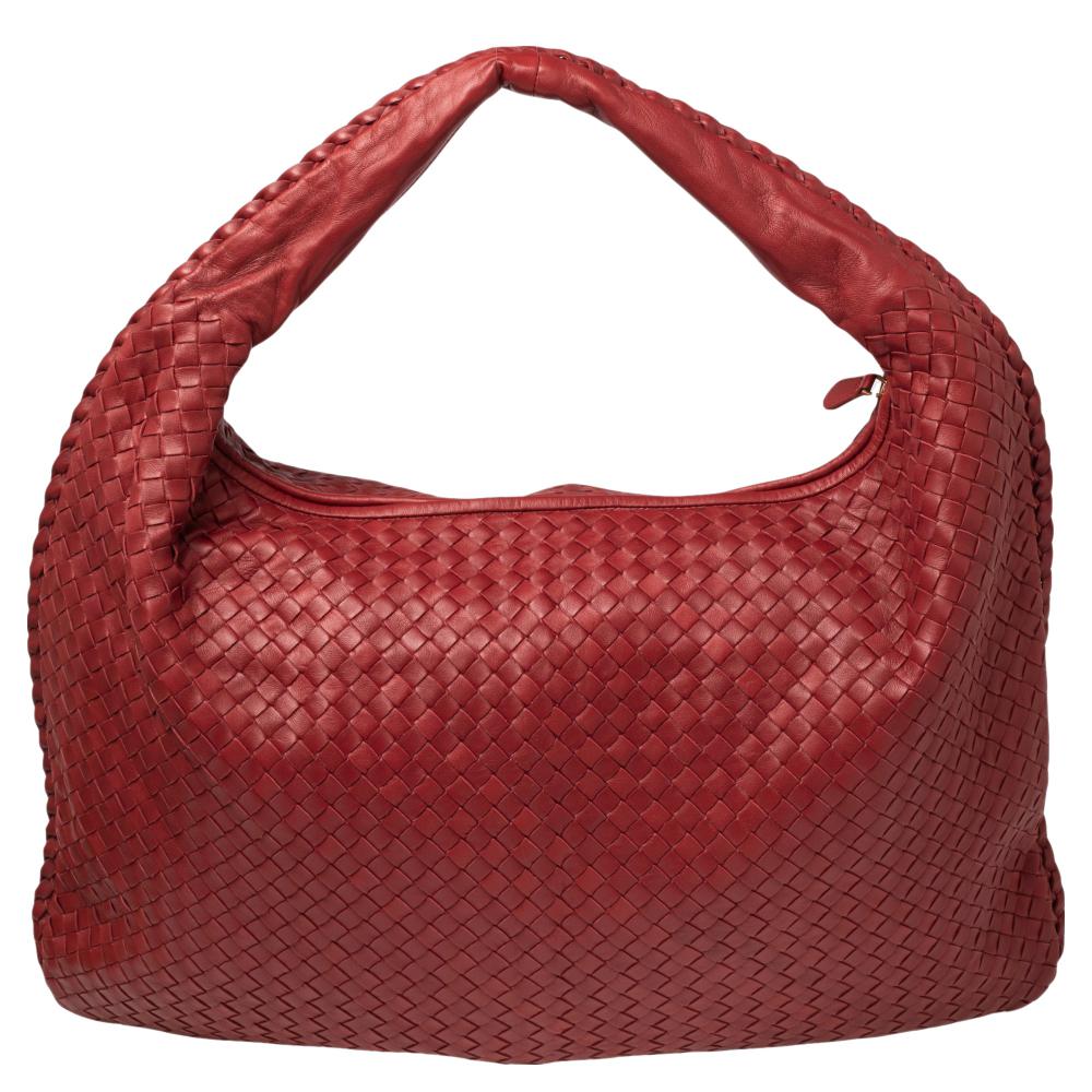 The excellent craftsmanship of this Bottega Veneta hobo ensures a brilliant finish and a rich appeal. Woven from leather in the signature Intrecciato pattern, the red-hued bag is provided with minimal gold-tone hardware. It features a loop handle