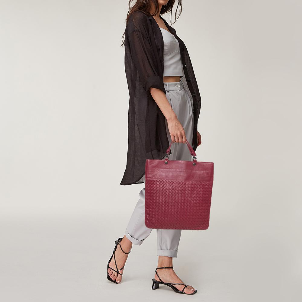 Featuring two handles at the top and a sleek red exterior enhanced with the Intrecciato pattern, this Bottega Veneta Slim tote exudes just the right amount of luxury. The leather bag features a capacious suede compartment to house all your