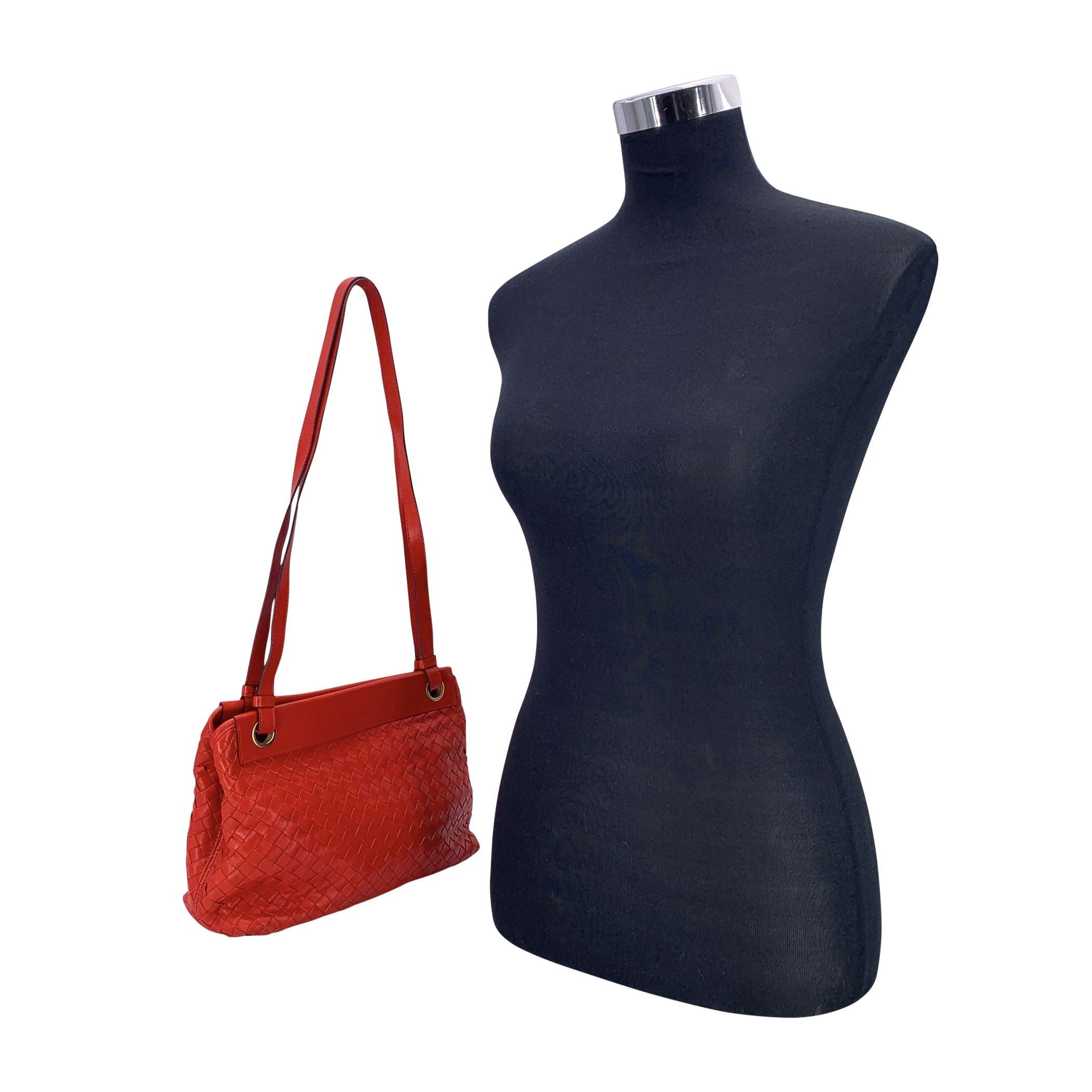 Eleganza di Bottega Veneta: borsa tote Intrecciato rossa, realizzata in nappa. Questo design senza tempo presenta due manici a spalla e una chiusura con bottone magnetico sulla parte superiore. L'interno è diviso in due scomparti principali con una