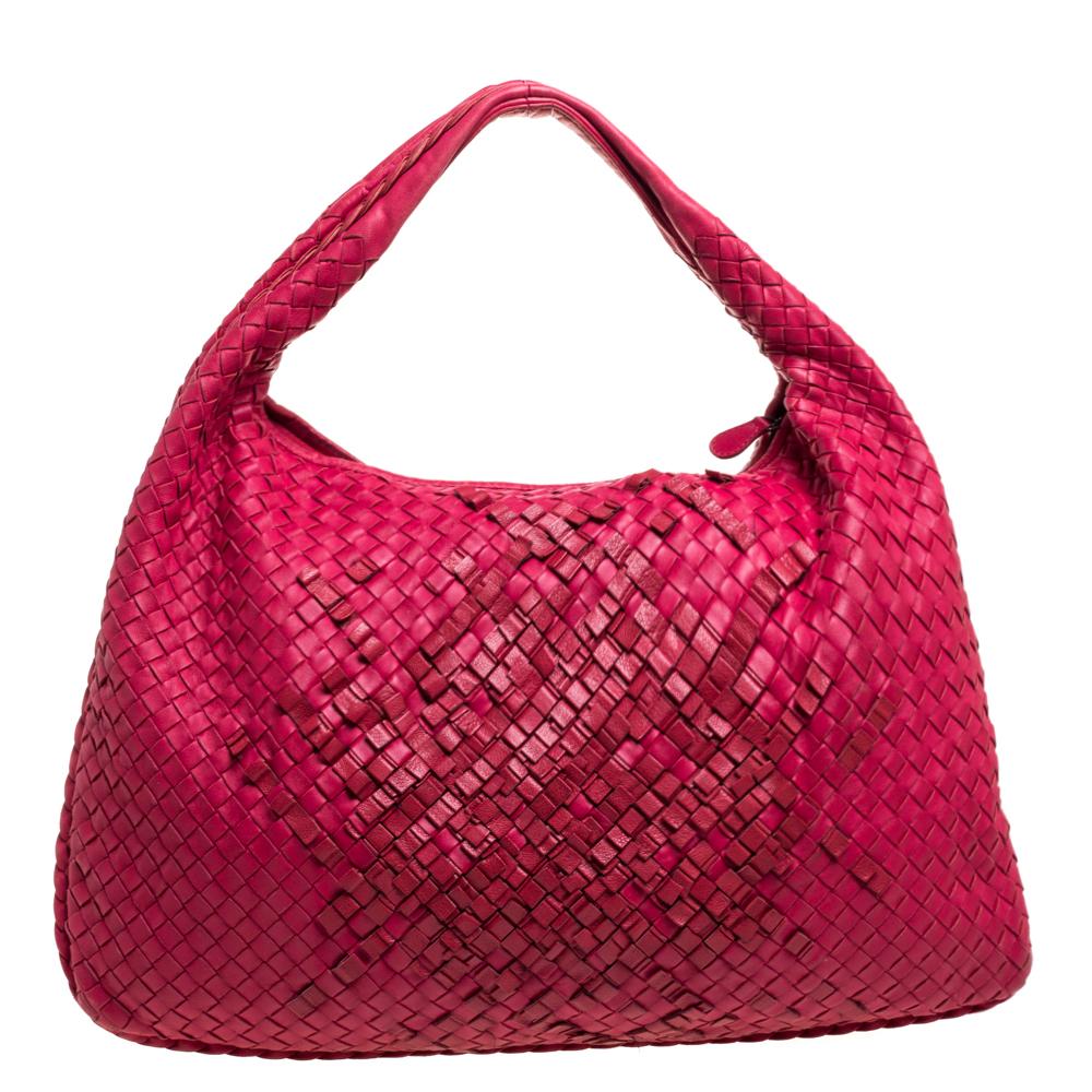 Luxuriously designed, this Veneta hobo from Bottega Veneta is splendid to look at and flaunt this season. It has been crafted from red leather in the brand's signature Intrecciato pattern and features a single top handle. It opens to a suede-lined