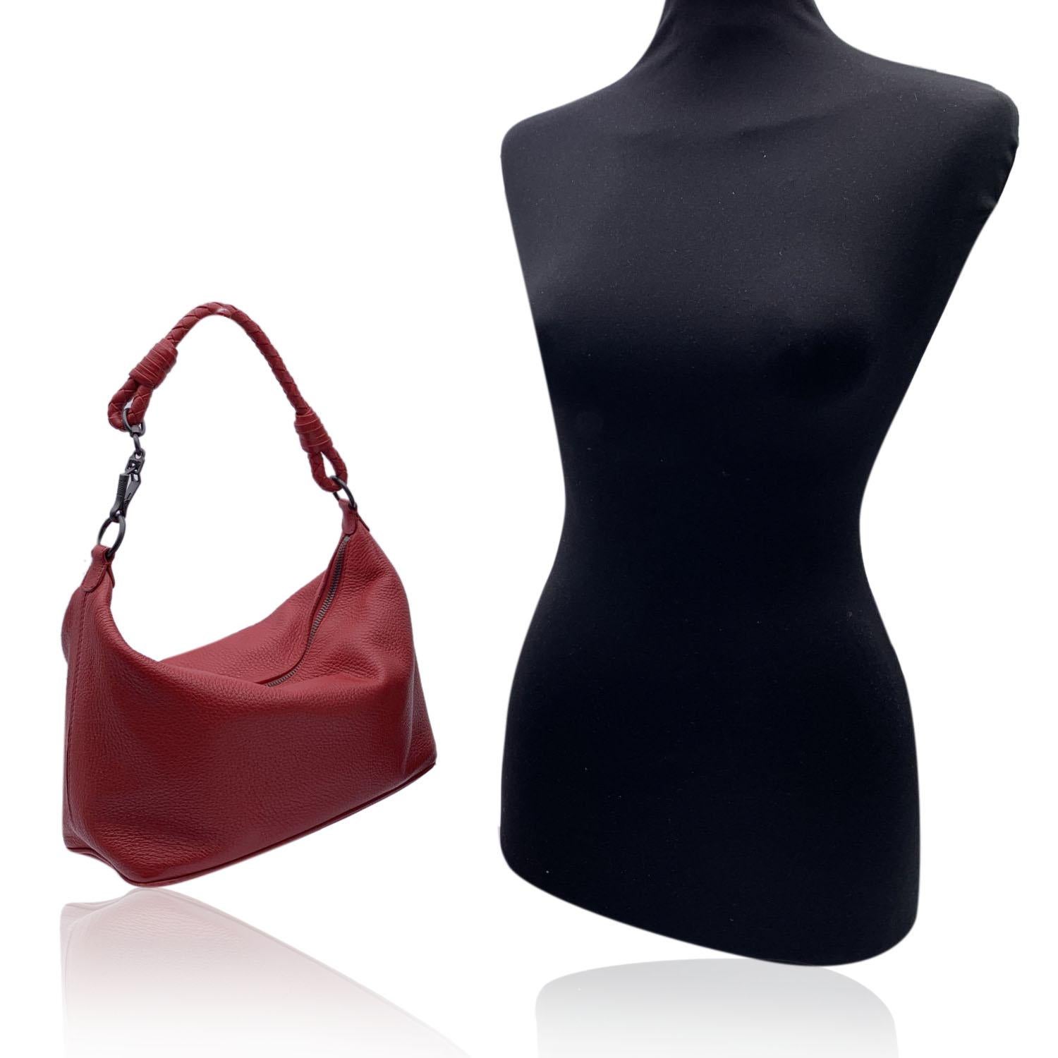 Bottega Veneta Hobo Shoulder Bag in red leather. Soft, boxy shape and a minimalistic appeal. Practical woven leather strap is detailed with a gunmetal-finish spring clip. Upper zipper closure. Velvety suede-lined interior. 'Bottega Veneta - made in