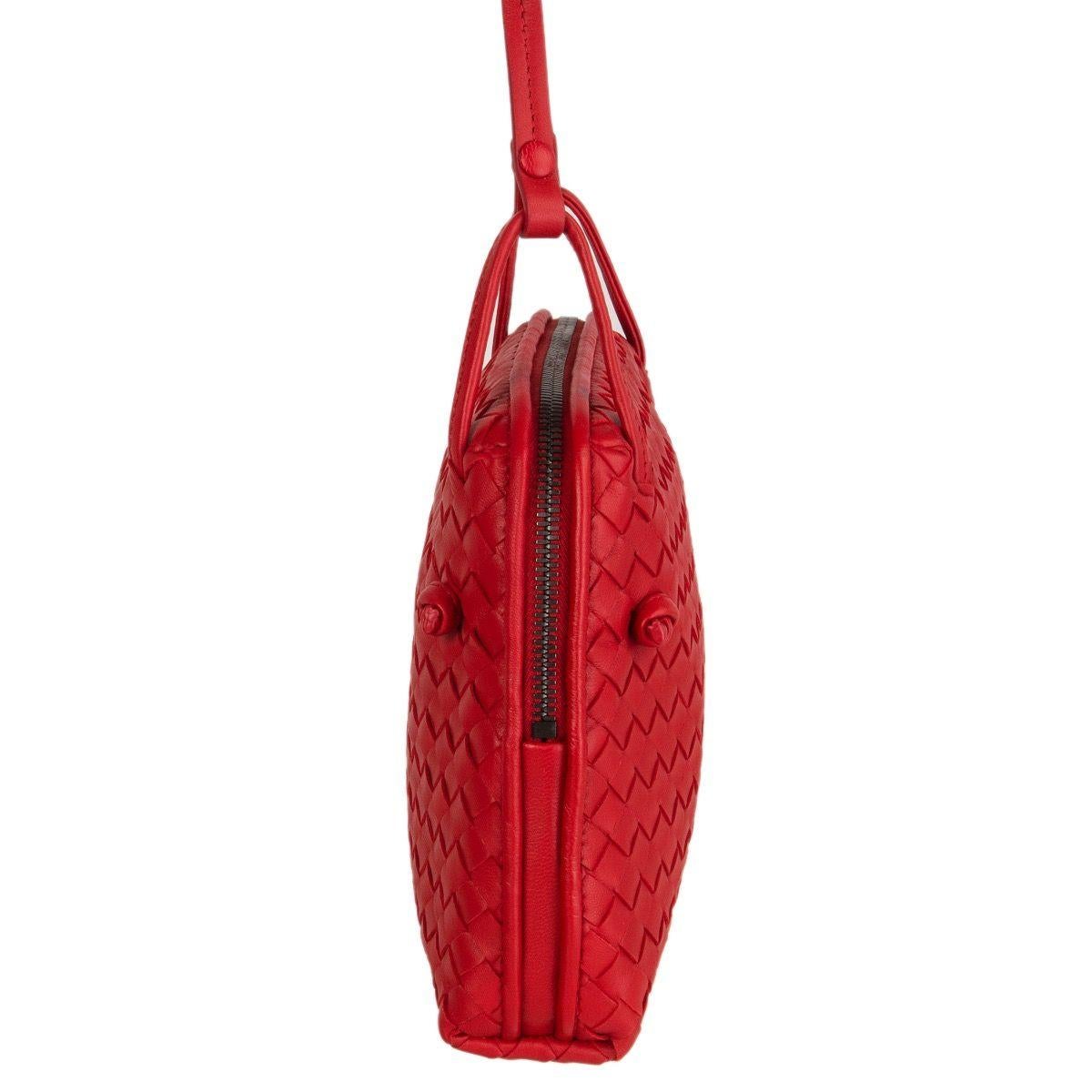 Bottega Veneta 'Nodini' cross-body in red woven nappa leather. Opens with a two-way zipper on top. Lined in dark taupe suede with one open pocket against the front and a zipper pocket against the back. Has an adjustable shoulder strap. Comes with a