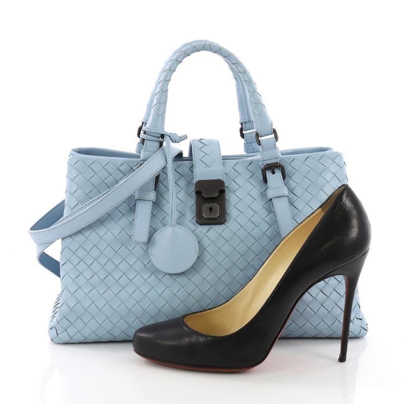 This Bottega Veneta Roma Handbag Intrecciato Nappa Small, crafted in light blue intrecciato nappa leather, features dual woven leather handles with buckle detailing and gunmetal-tone hardware. Its push lock tab opens to taupe suede interior divided