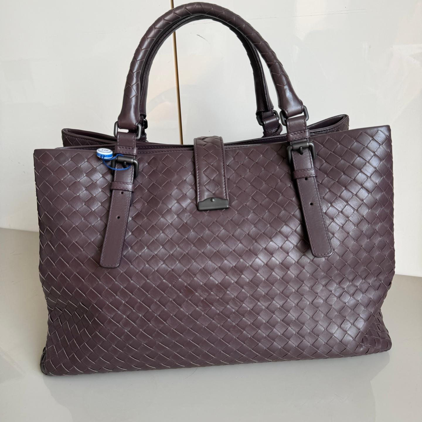 Bottega Veneta Roma Large Intrecciato Nappa Marrone Scuro 35cm
Queste sono foto professionali della borsa offerta da Luxbags.
Questa borsa Bottega Veneta Roma è un pezzo di lusso eccezionale, realizzato con l'iconica pelle marrone scuro con la trama