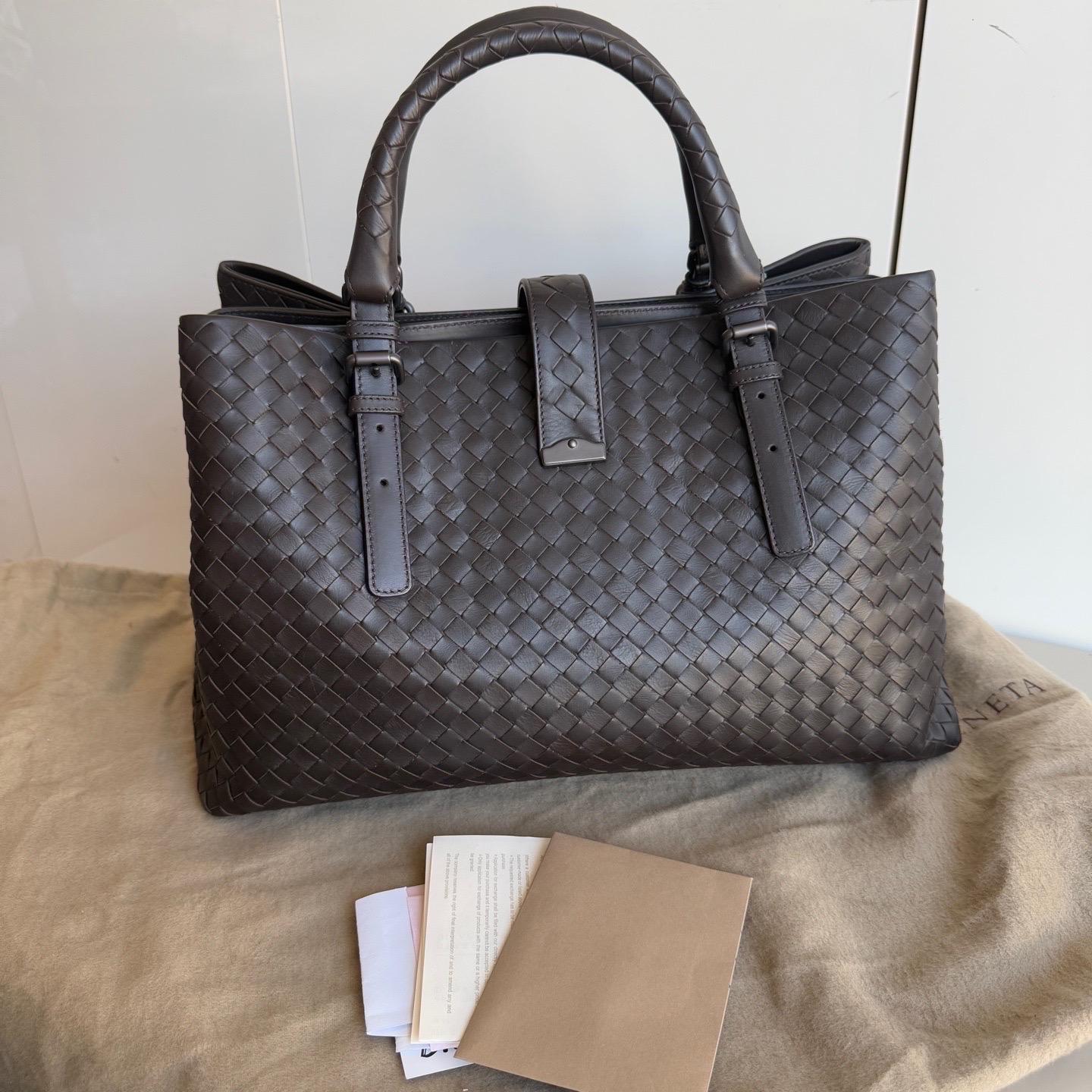 This Bottega Veneta Roma Bag is an exceptional piece of luxury, crafted from iconic dark brown leather with the instantly recognizable Intrecciato weave. Roomy enough for all your essentials, it's the perfect winter accessory for stylish and