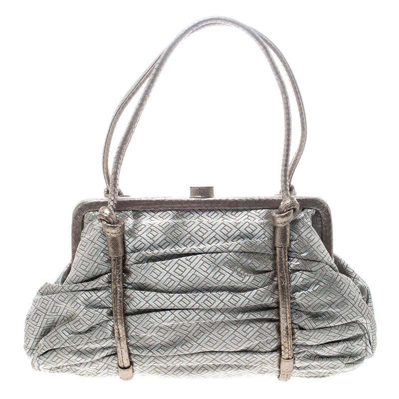 Made of silver fabric with bronze trims, this satchel makes an ideal addition to your wardrobe. Keep the attention on this Bottega Veneta bag by pairing it with statement pants and nude pumps. The suede interior makes it a useful accessory. The