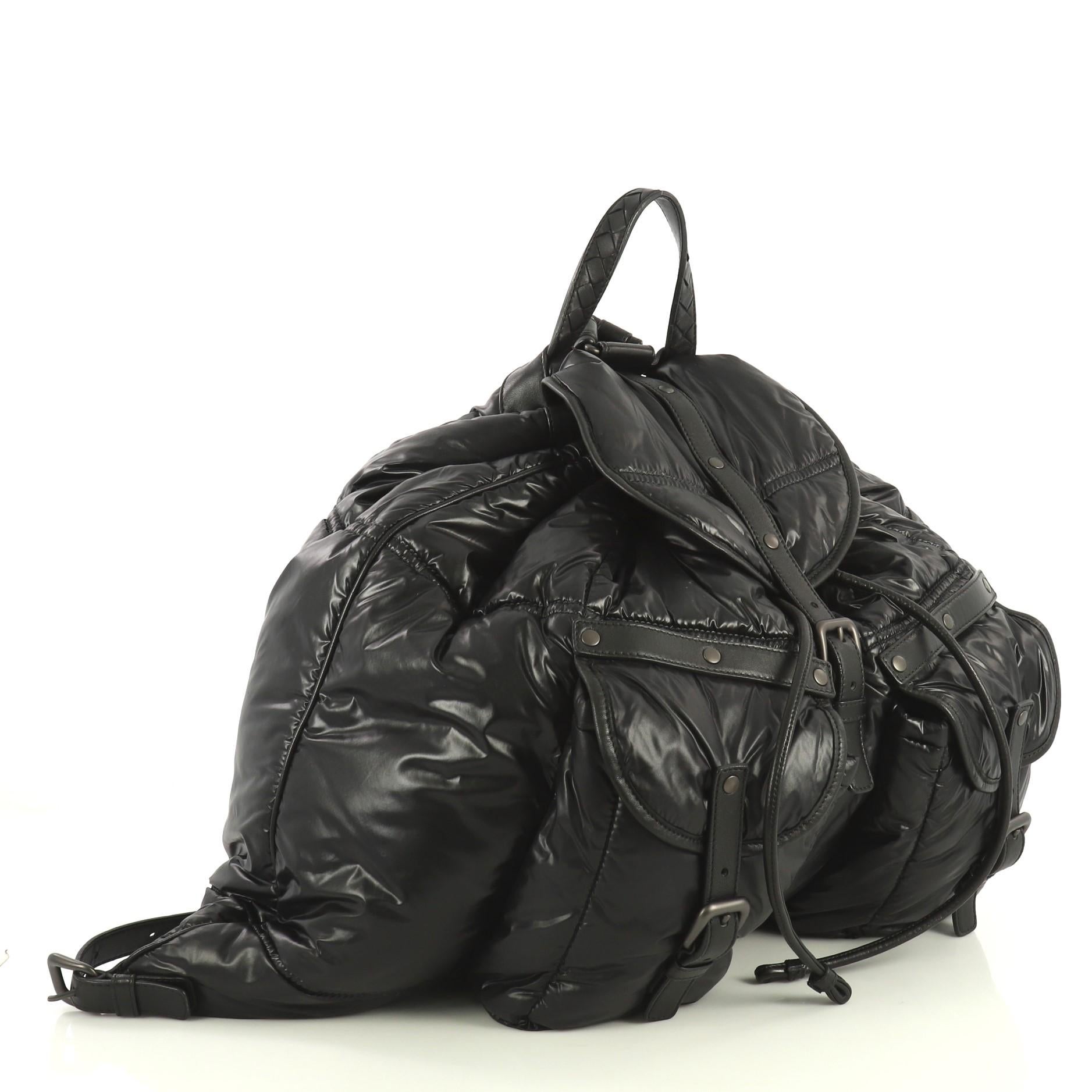 This Bottega Veneta Spinnaker Backpack Nylon Large, crafted from black nylon, features dual adjustable straps, two front pockets with buckle closure and matte gunmetal-tone hardware. Its flap with buckle and drawstring closure opens to a black nylon