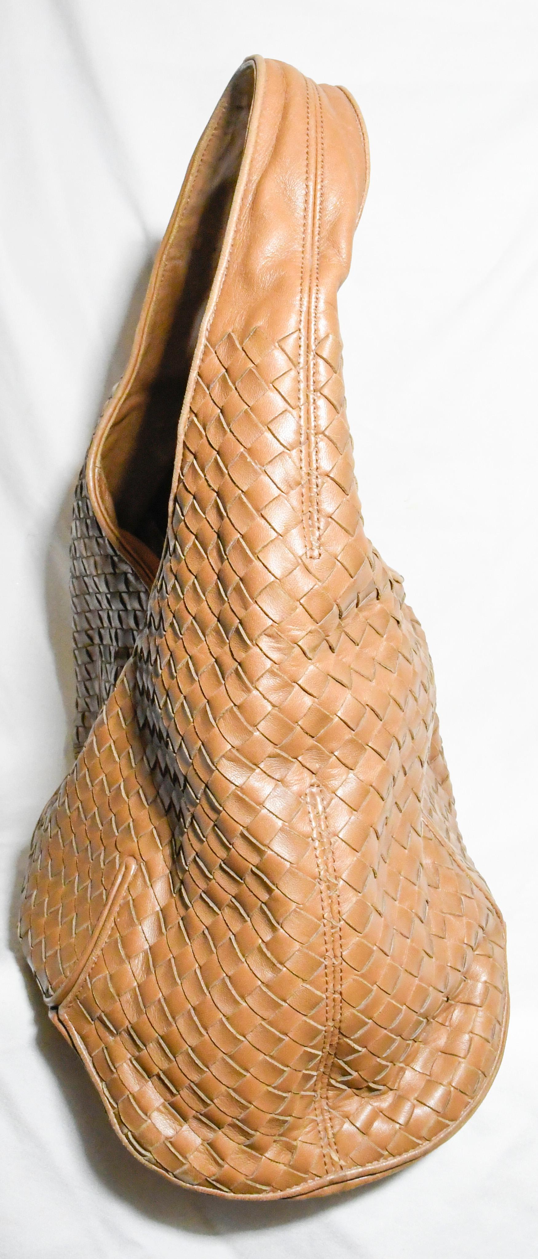 Bottega Veneta tan leather hobo bag features a woven (intrecciato) leather body.  This single flat shoulder strap bag includes a top zipper closure that opens to a light blue suede interior with a zipper side pocket.
This bag is in very good