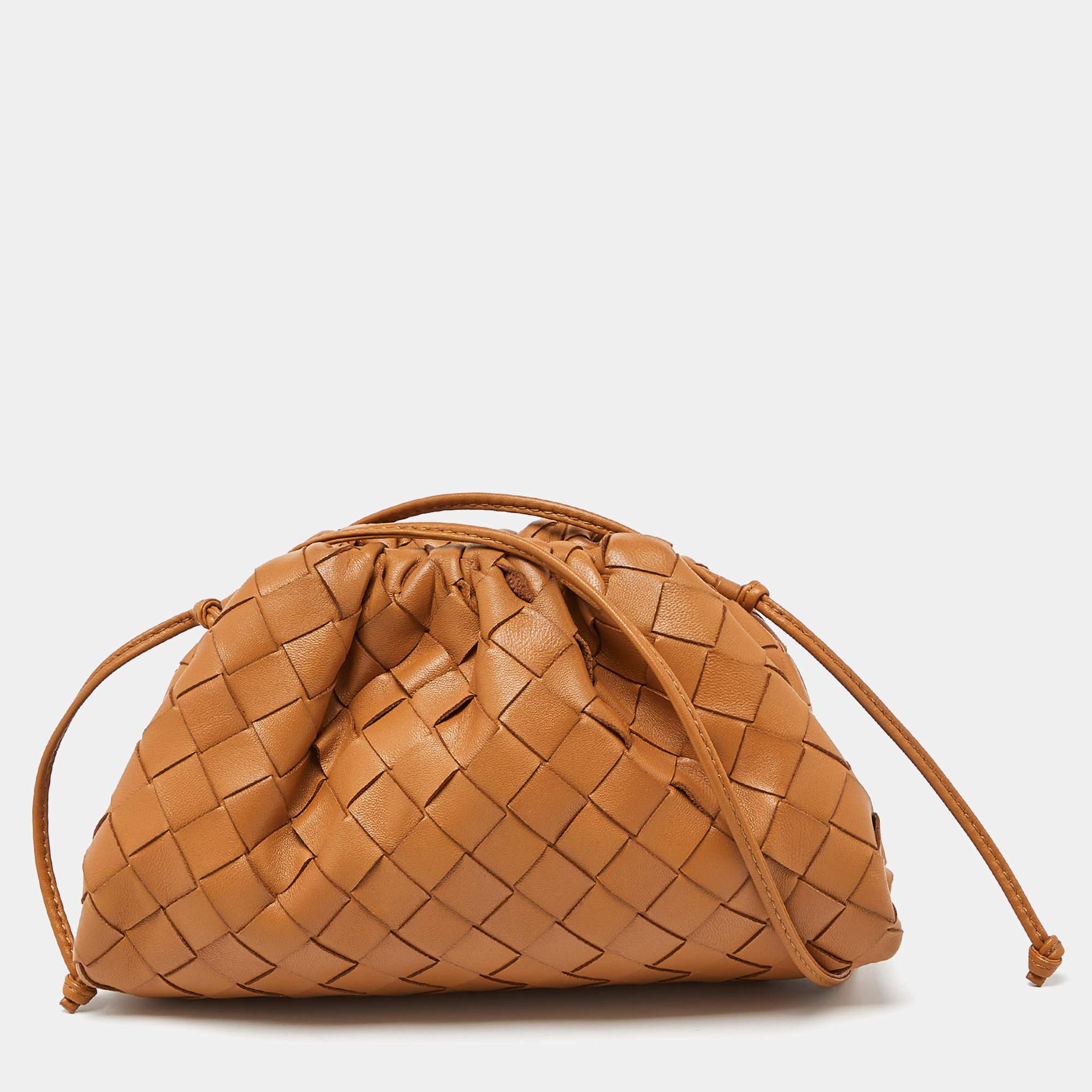 The House of Bottega Veneta has created this stunning 'The Pouch' bag to make an effortless style statement wherever you go. It is made from tan Intrecciato leather and comes with distinct gold-tone hardware. It has a neat leather-lined interior and