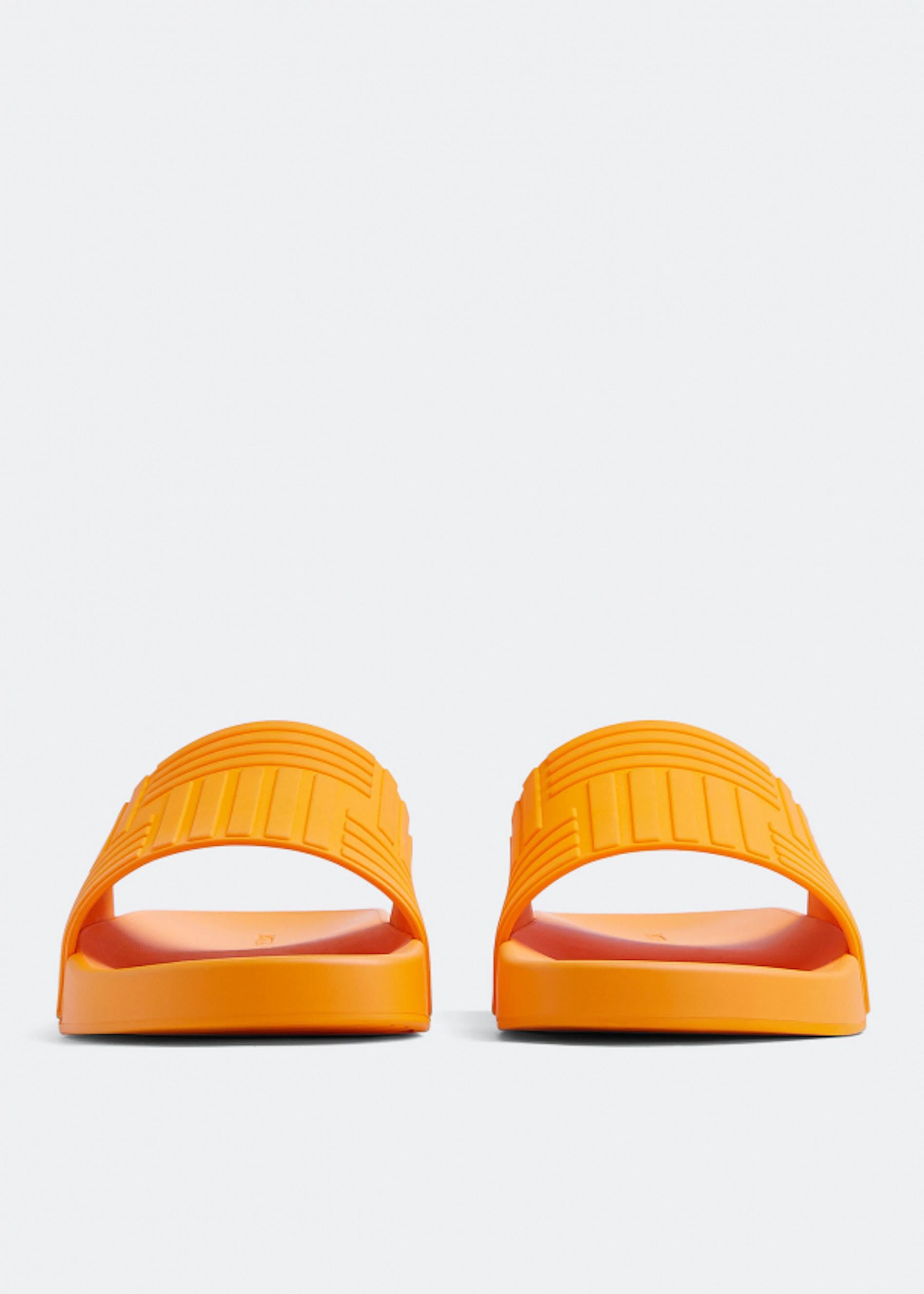 These Bottega Veneta Rubber slides will be your best companion this summer as you relax and enjoy the beach and pool. Constructed in rubber with a broad upper band, they make any outfit fun with their pop color hue. Brand new, never worn, in all