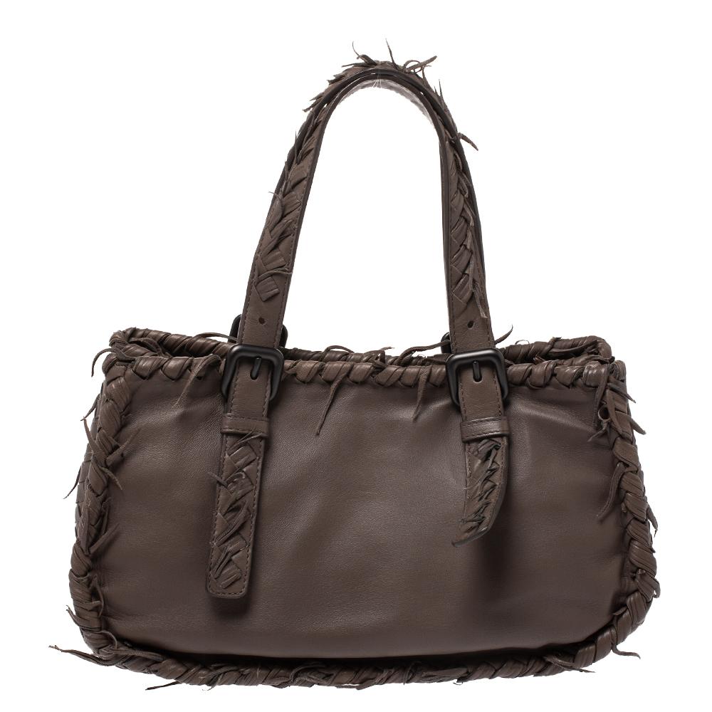 Questa elegante e spaziosa borsa in pelle è abbastanza lussuosa da elevare qualsiasi look. È progettata con pannelli intrecciati sui lati e sul fondo e frange sul contorno e sui manici. Questa borsa ha una fodera interna in pelle scamosciata. Tieni