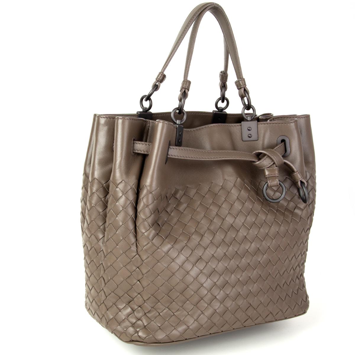 Bottega Veneta Intrecciato shoulder bag in taupe smooth nappa leather featuring a decorative drawstring closure. Lined in dark taupe suede with one zipper pocket against the back and one open pocket against the front. Comes with a detachable