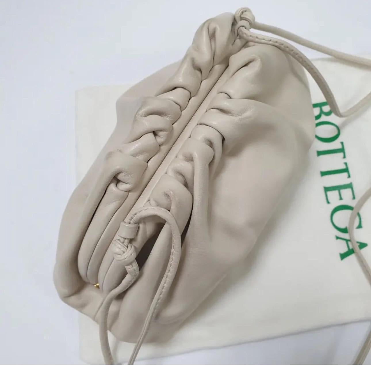 Pour Bottega Veneta, il est facile de combiner une esthétique minimale avec des nuances modernes. La pochette Teen Pouch est en cuir beige. Il a une construction souple avec des fronces sur l'empeigne. Il est très agréable de le glisser sous le bras