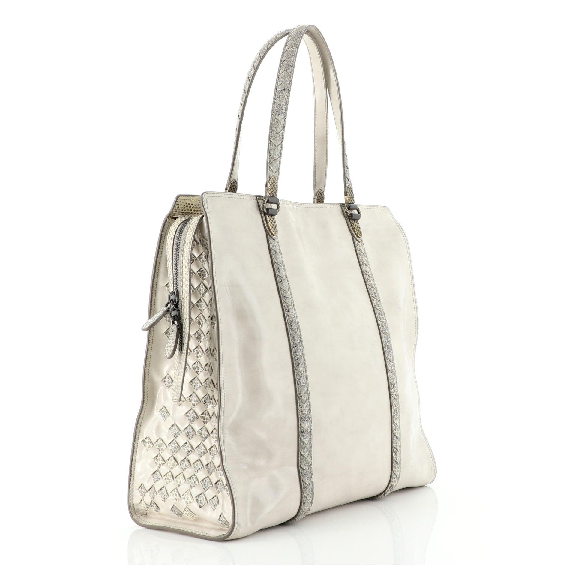 Bottega Veneta Tote Patent with Intrecciato Snakeskin Detail Tall
White Patent Intrecciato Leather

Condition Details: Minor wear and darkening on base corners, moderate creasing and marks on exterior, lifting of scales on snakeskin trims. Wear and