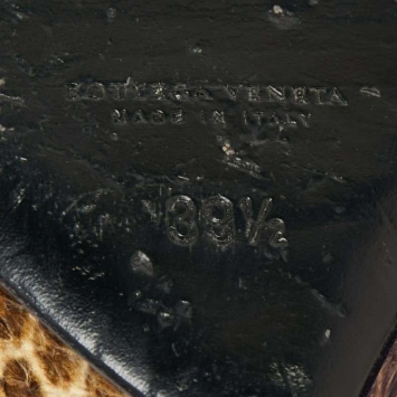 Este par de sandalias atemporales de Bottega Veneta lucen aún mejor en los pies. Los zapatos tienen un diseño elegante de piel de serpiente y ante, con puntera abierta, tacón alto y tira con hebilla para un acabado elegante.