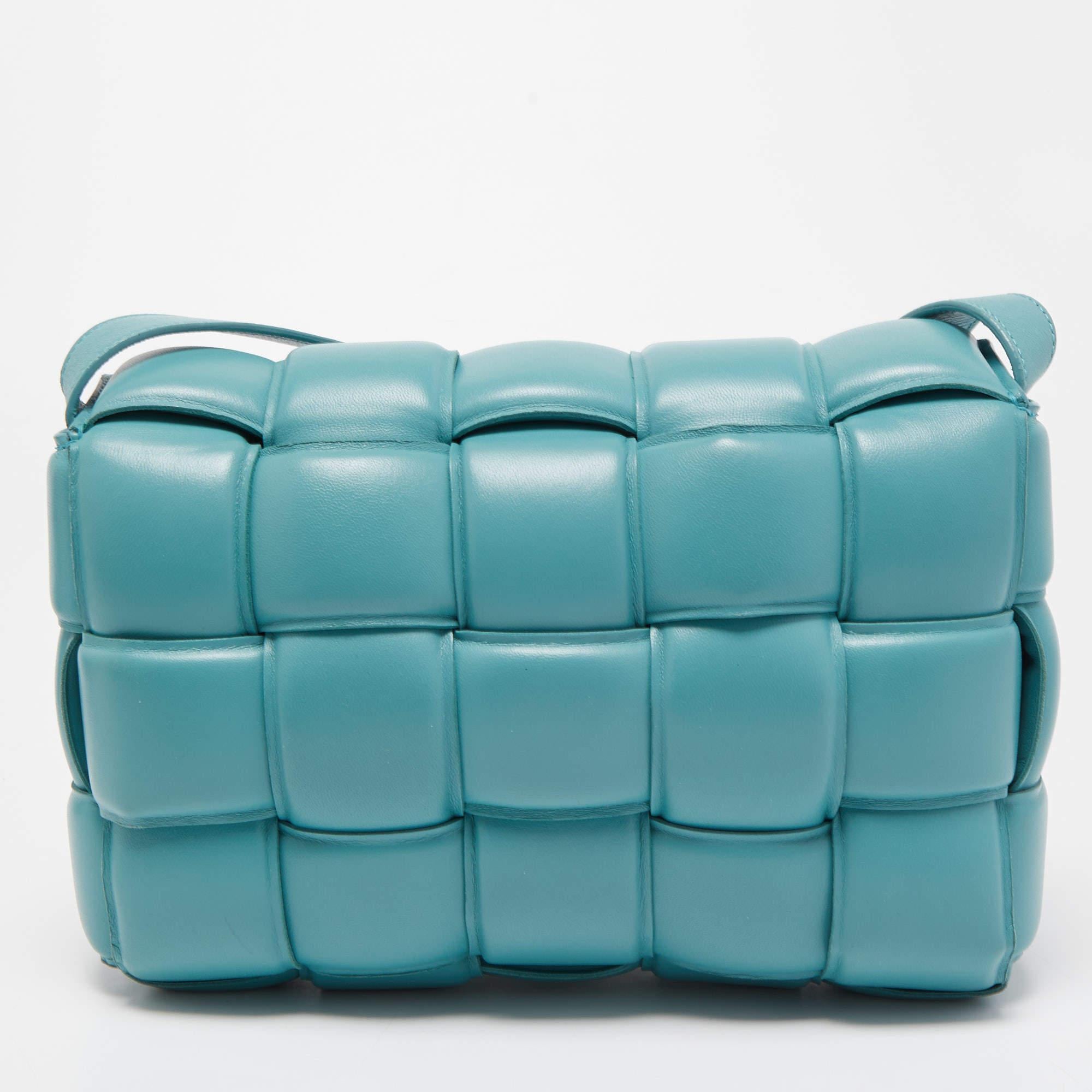Meet the iconic Cassette bag from the house of Bottega Veneta. We have here one in turquoise leather, flaunting a padded weave and a long flat strap. The insides are well-sized to fit your phone, wallet, and make-up must-haves. So, do not think