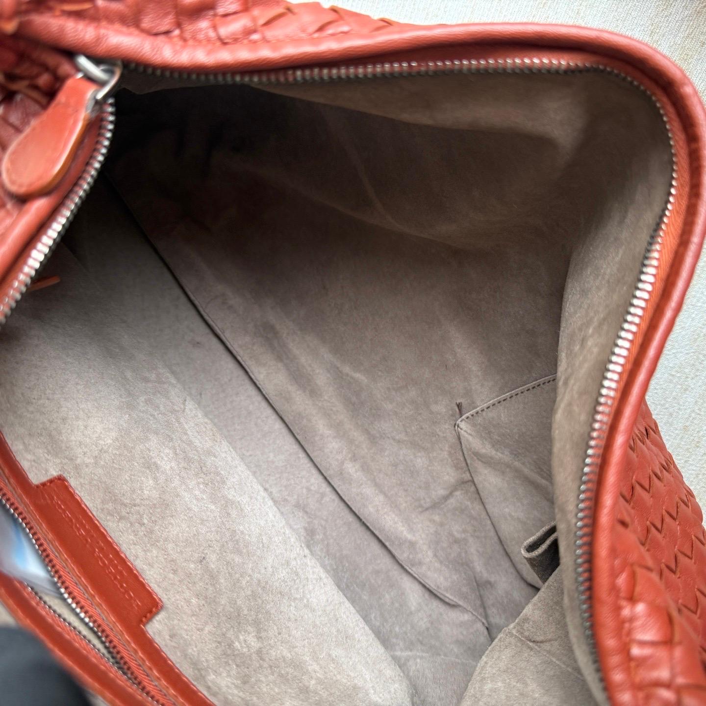 This Bottega Veneta Veneta Bag is an exceptional piece of luxury, crafted from iconic lambskin leather with the instantly recognizable Intrecciato weave. This bag is roomy enough for all your essentials, it's the perfect accessory for stylish and