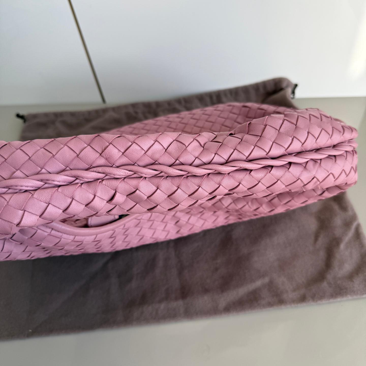 This Bottega Veneta Veneta Bag is an exceptional piece of luxury, crafted from iconic lambskin leather with the instantly recognizable Intrecciato weave. Boasting the newer design with intrecciato weave on top of the handle, this bag is roomy enough