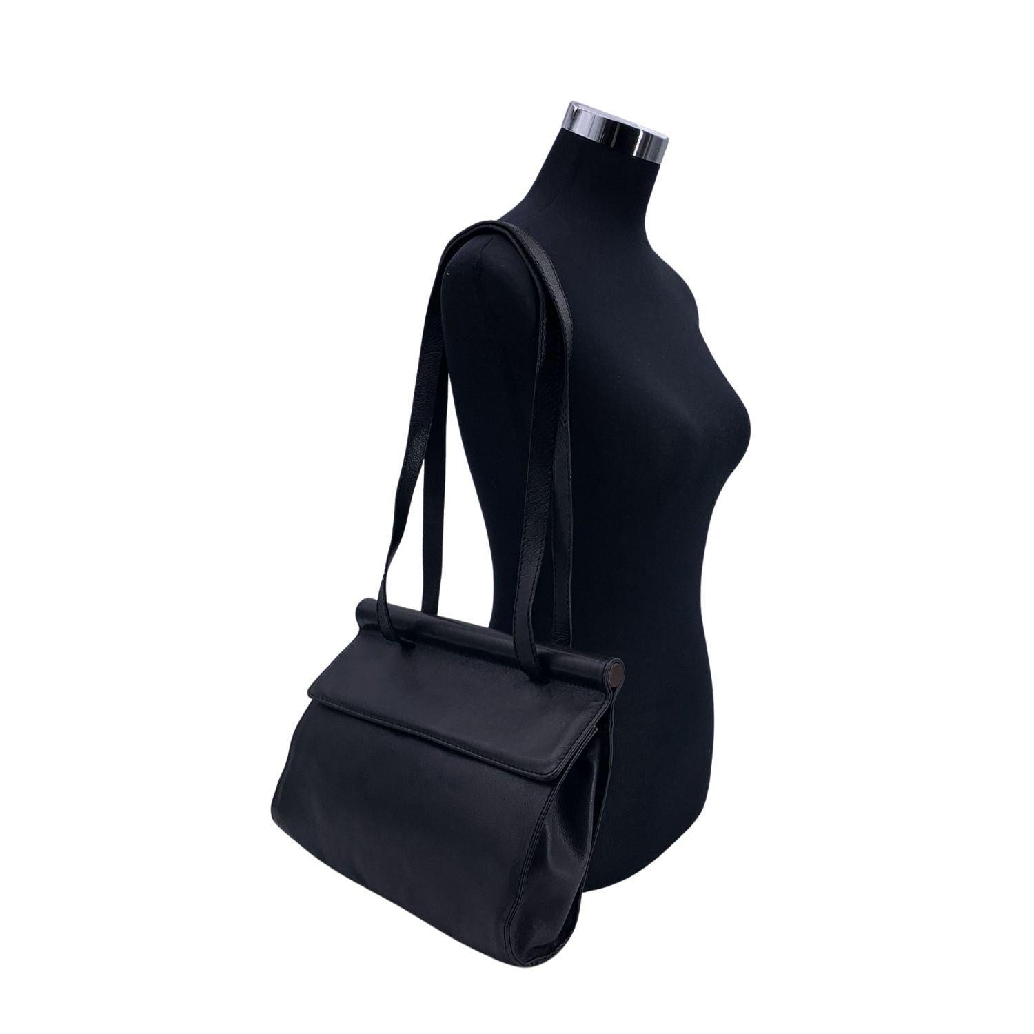Sac à bandoulière Tote en cuir noir de Bottega Veneta. Double bandoulière longue. Rabat avec fermeture à bouton magnétique. Doublure en cuir noir. 1 poche latérale zippée à l'intérieur. Etiquette 'Bottega Veneta - Made in Italy' à l'intérieur.