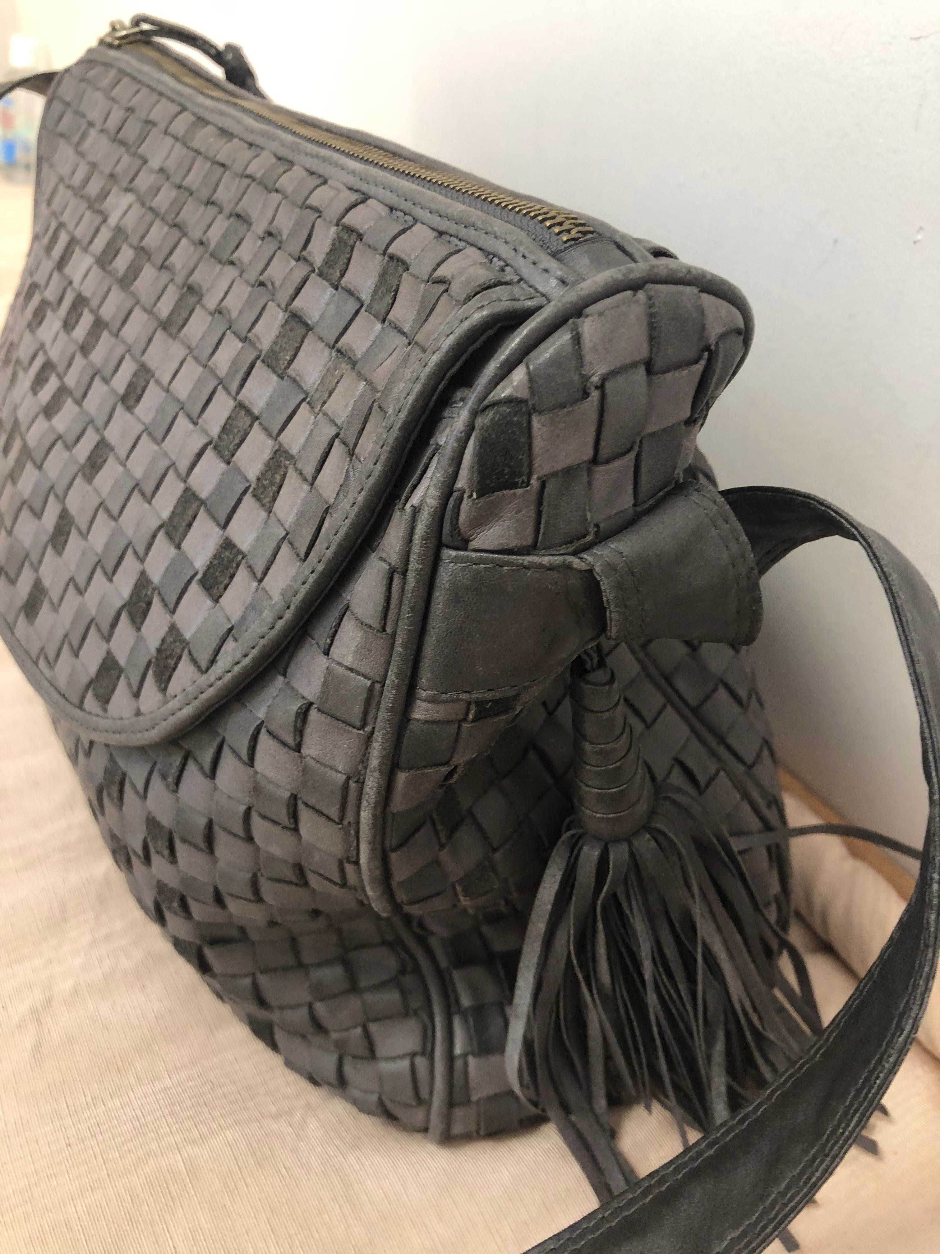 Bolso cruzado Bottega Veneta Intrecciato en tonos grises. El bolso está en excelente estado vintage, con piel flexible y forro de cuero negro. La bolsa tiene un bolsillo delantero con solapa que se abre en un útil compartimento, y se cierra mediante