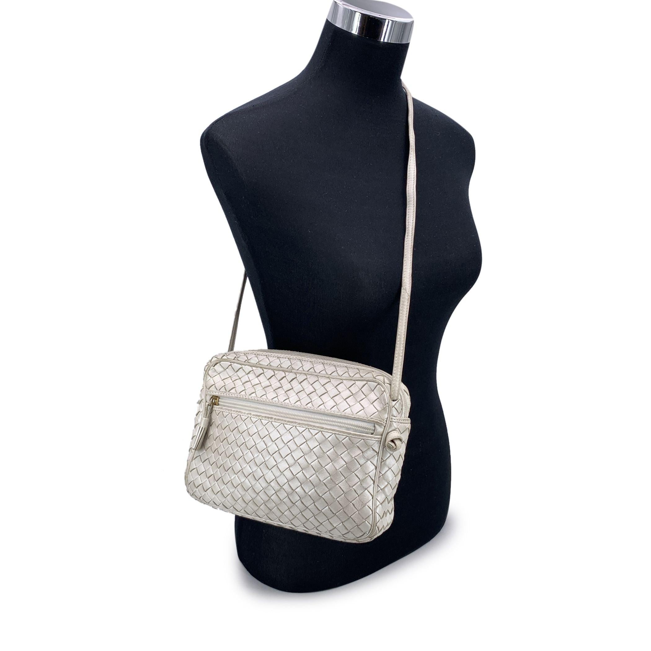 Step into a world of understated luxury with this stunning Bottega Veneta pearly white crossbody bag, a perfect blend of elegance and craftsmanship. Woven from luxurious white pearly nappa leather, this bag is a true testament to the brand's