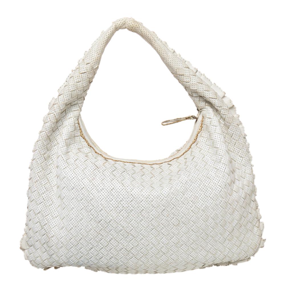 The excellent craftsmanship of this Bottega Veneta hobo ensures a brilliant finish and a rich appeal. Woven from leather in their signature Intrecciato pattern, the white-hued bag is provided with a loop handle and a top zip closure, which secures a