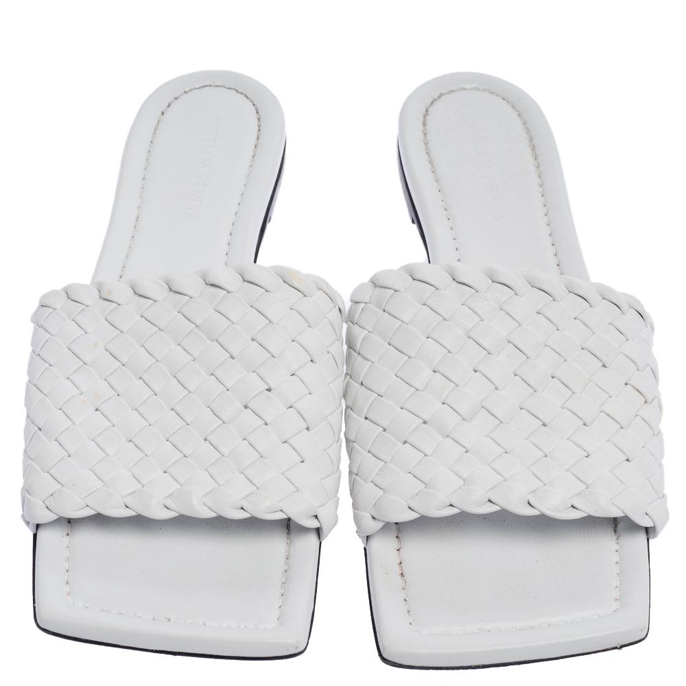 These white slide sandals exhibit the best of Bottega Veneta's dedication to timeless designs and meticulous craftsmanship. They are crafted from leather, designed with open square toes and signature Intrecciato-woven vamp straps to hold the