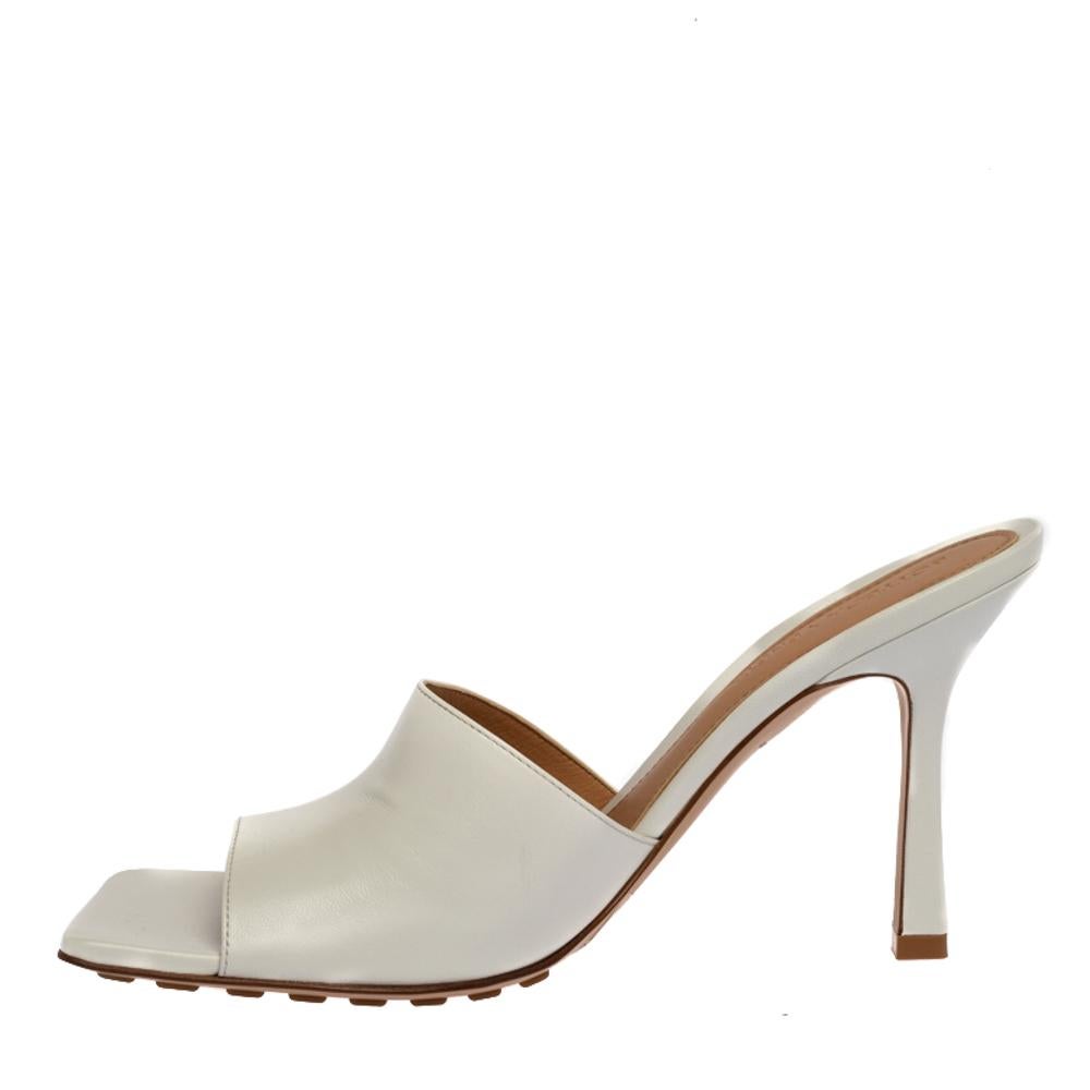 Square toe shoes from Bottega Veneta are certainly having a major fashion moment. These slide sandals, designed with wide straps on the vamps, are gorgeous! They are rendered in white leather with labeled insoles and high heels. Grab this pair