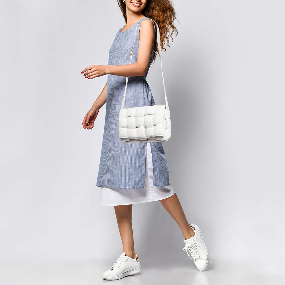 The current bag on many fashionistas' minds is the Cassette bag from the house of Bottega Veneta. We have here the one in white leather, flaunting a padded maxi weave and a shoulder strap. The insides are sized to fit your phone and other little