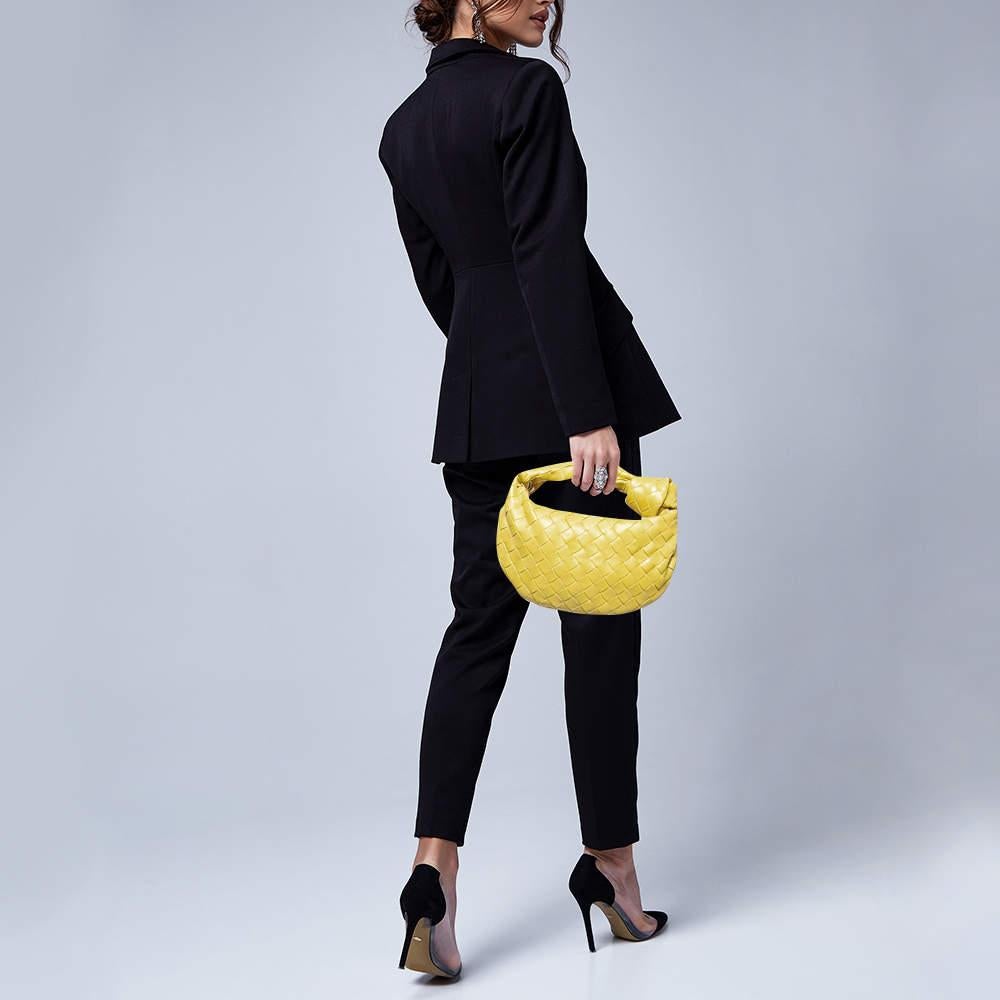 Le sac JODI de Bottega Veneta est réalisé en cuir selon la technique de tissage Intrecciato signature de la marque, pour une silhouette sans couture. Ce mini sac qui incarne l'élégance et le charme subtil est retenu par une anse nouée. Le sac est